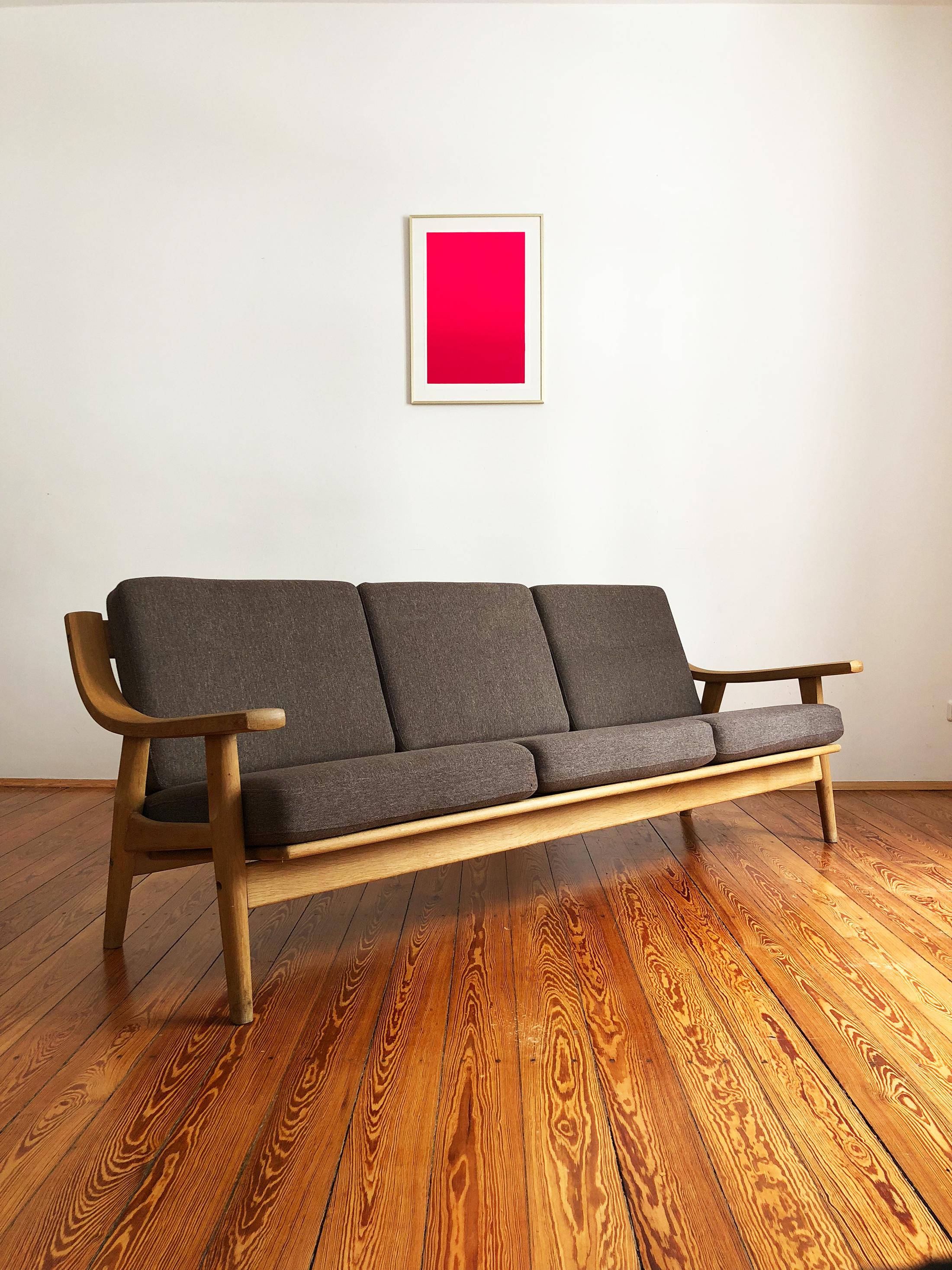 Sofa designed by Hans J. Wegner and produced by GETAMA, made out of solid oakwood. The Sofa shows best Danish quality craftsmanship. It comes with renewed box spring cushions.