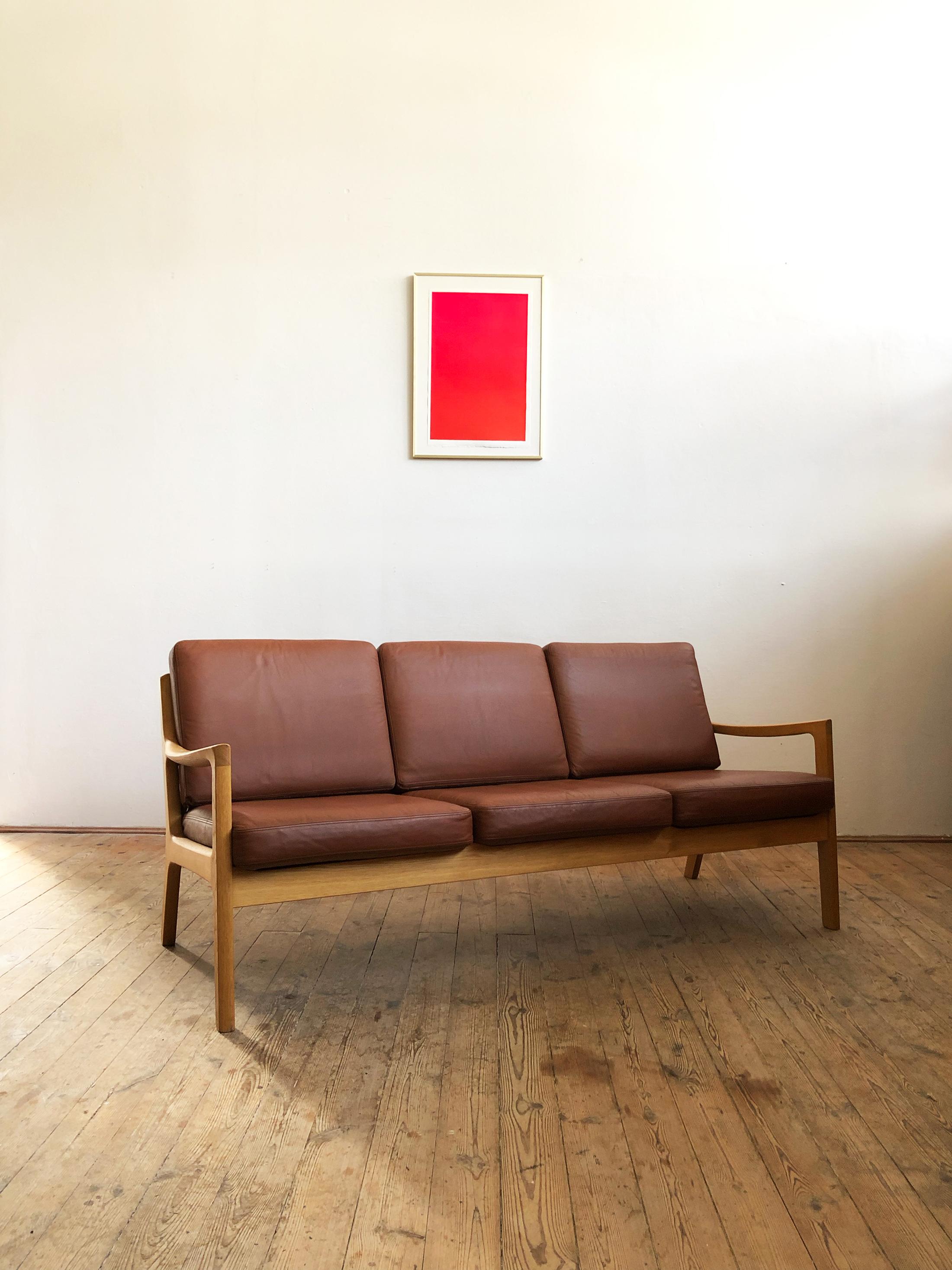This shapely and comfortable sofa was designed by Ole Wanscher for Poul Jeppesens Møbelfabrik. This piece comes in a very rare version made of oakwood with foam cushions and a leather cover.