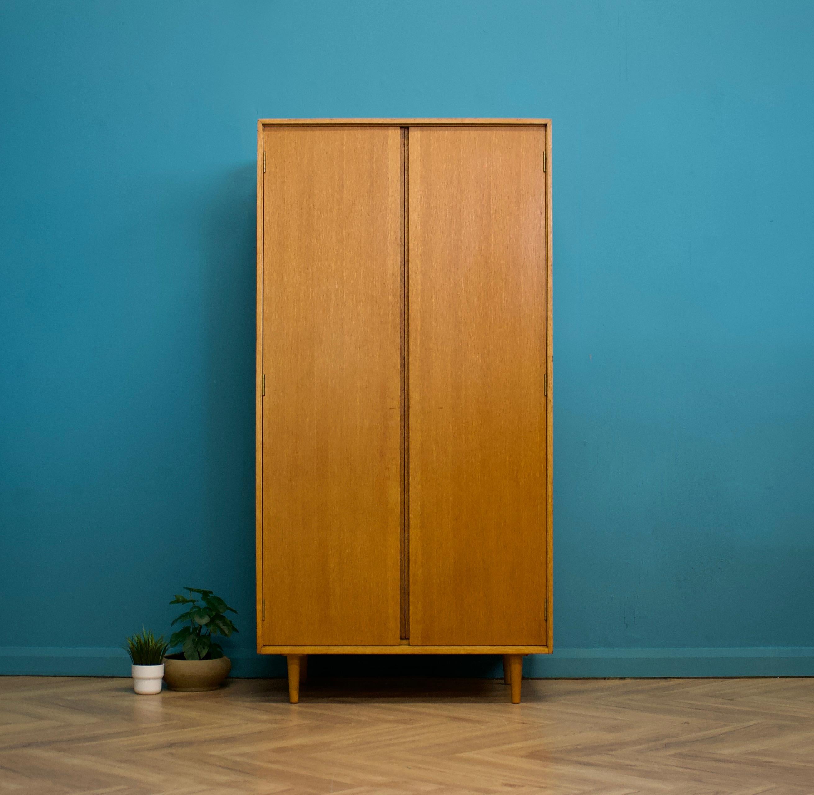 A freestanding double door teak wardrobe from Stag - in the Danish modern style
Made during the 1960s
Fitted out with a clothes rail and fixed shelving for ample storage.
The style of this wardrobe is minimalist - with it's clean lines, handless