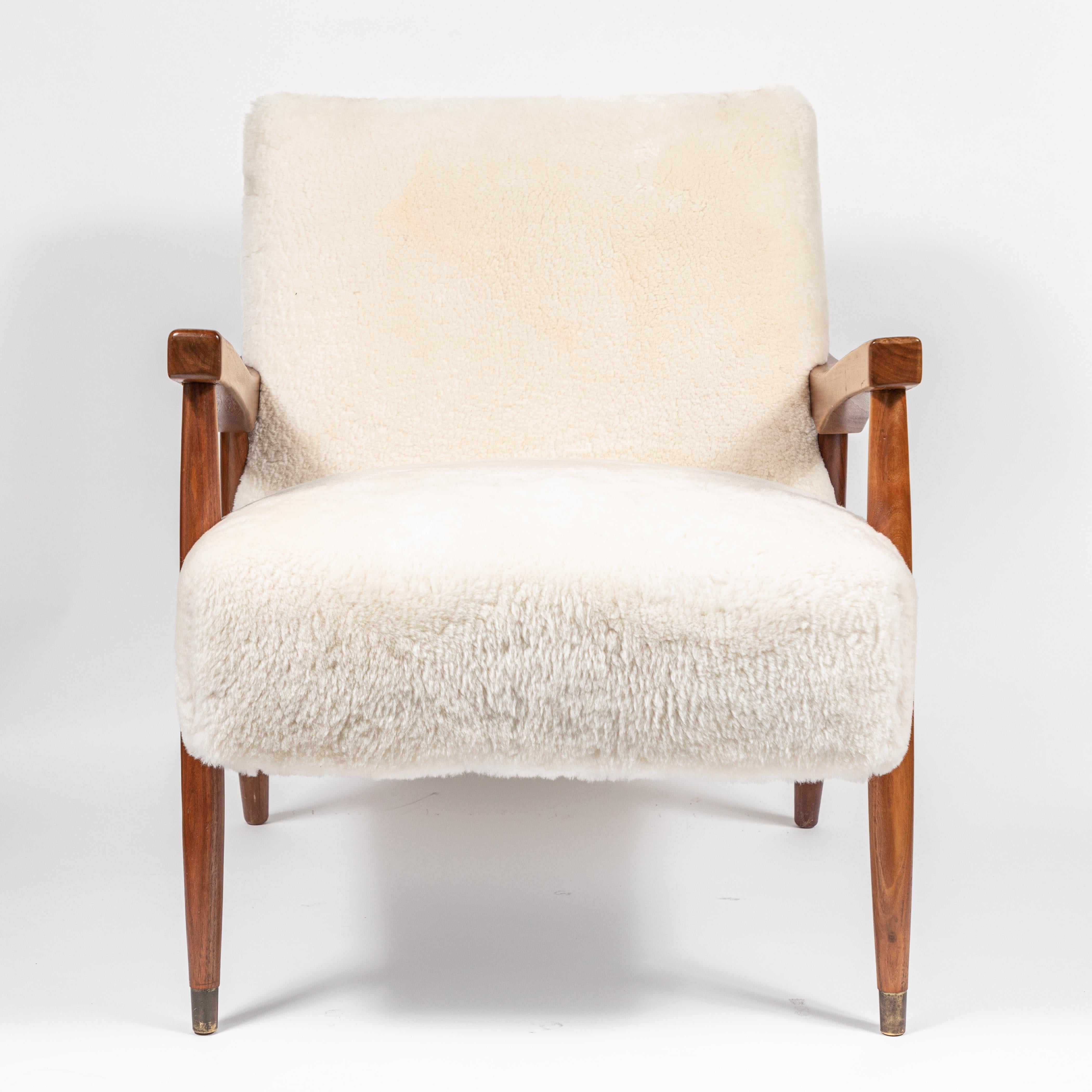 A beautiful, wooden sculptural mid century occasional chair that has been newly upholstered in white shearling and the wood has been newly refinished.

Featuring beautiful sculptural arms and interesting angles, a standout in any room.