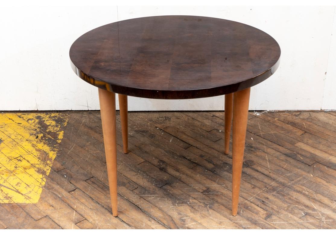 Mid Century/ Art Deco Beistelltisch von Gilbert Rohde
Dieser Beistelltisch von Gilbert Rhode zeichnet sich durch eine Platte aus exotischem, genopptem Walnussholz und konische Beine aus braunem Leder aus.
Herkunftsort sind die Vereinigten