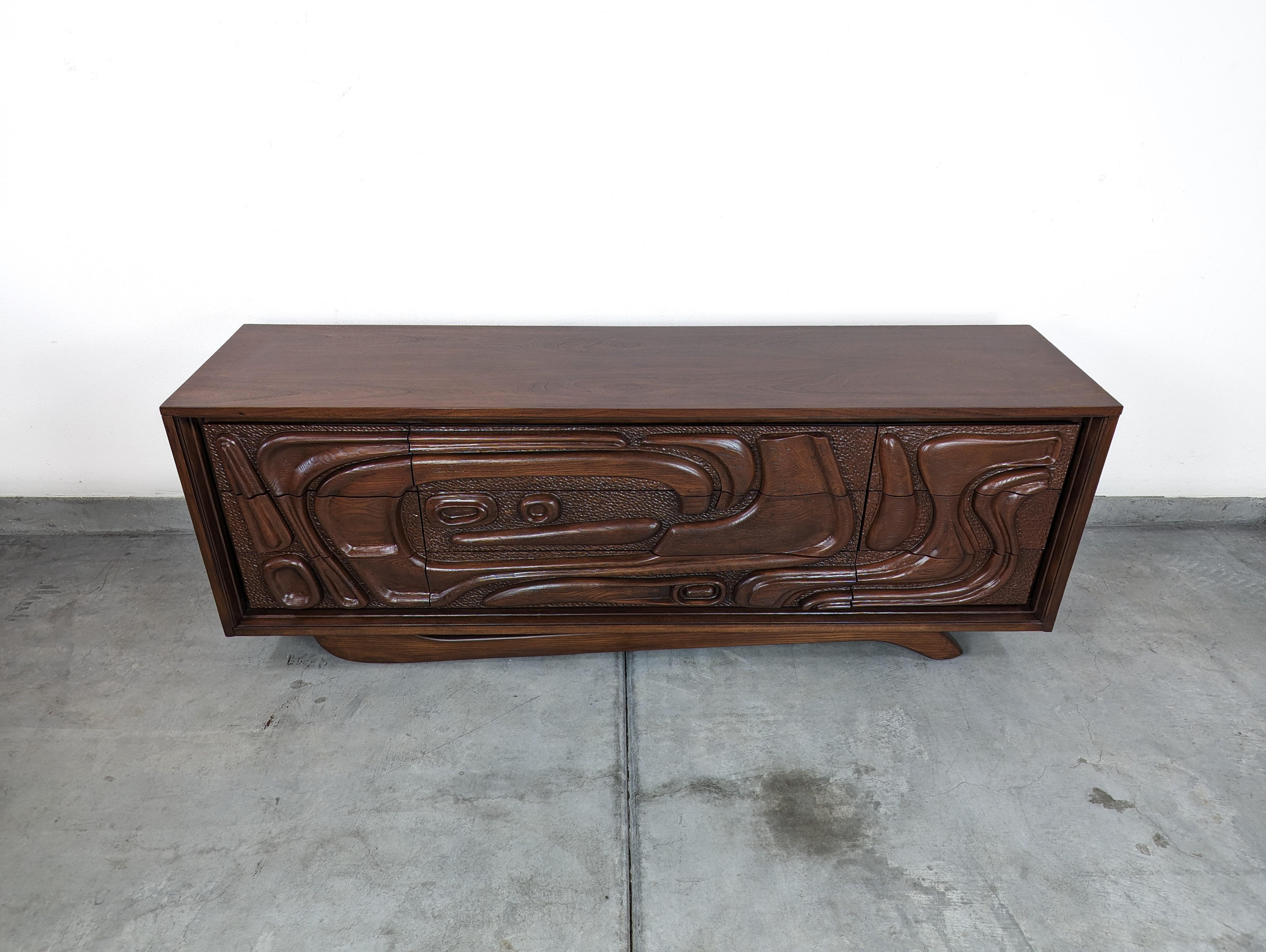 Immerse yourself in the nostalgic allure of the Californian surf culture with this exquisite vintage mid-century 'Oceanic' sculpted walnut dresser by Pulaski Furniture Corporation, dating back to the vibrant 1960s. A treasured relic of the era, this
