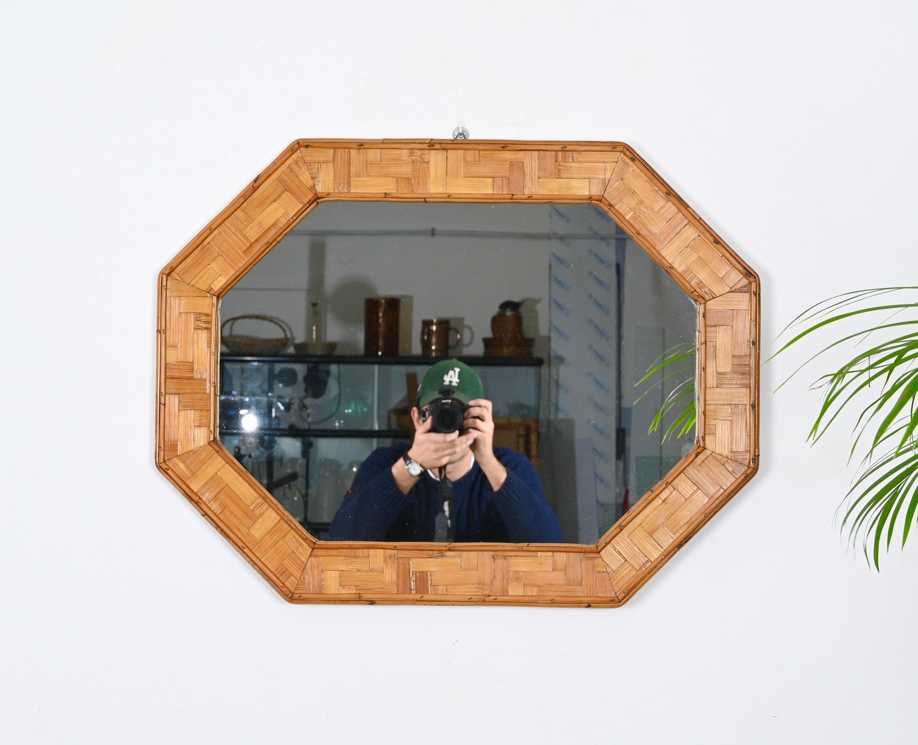 Lovely French Riviera octragonal mirror in woven rattan and bamboo. This fantastic piece was designed in Italy during the 1960s.

This mirror is fantastic thanks to its frame, made of straight lines given by the external and internal bamboo canes,