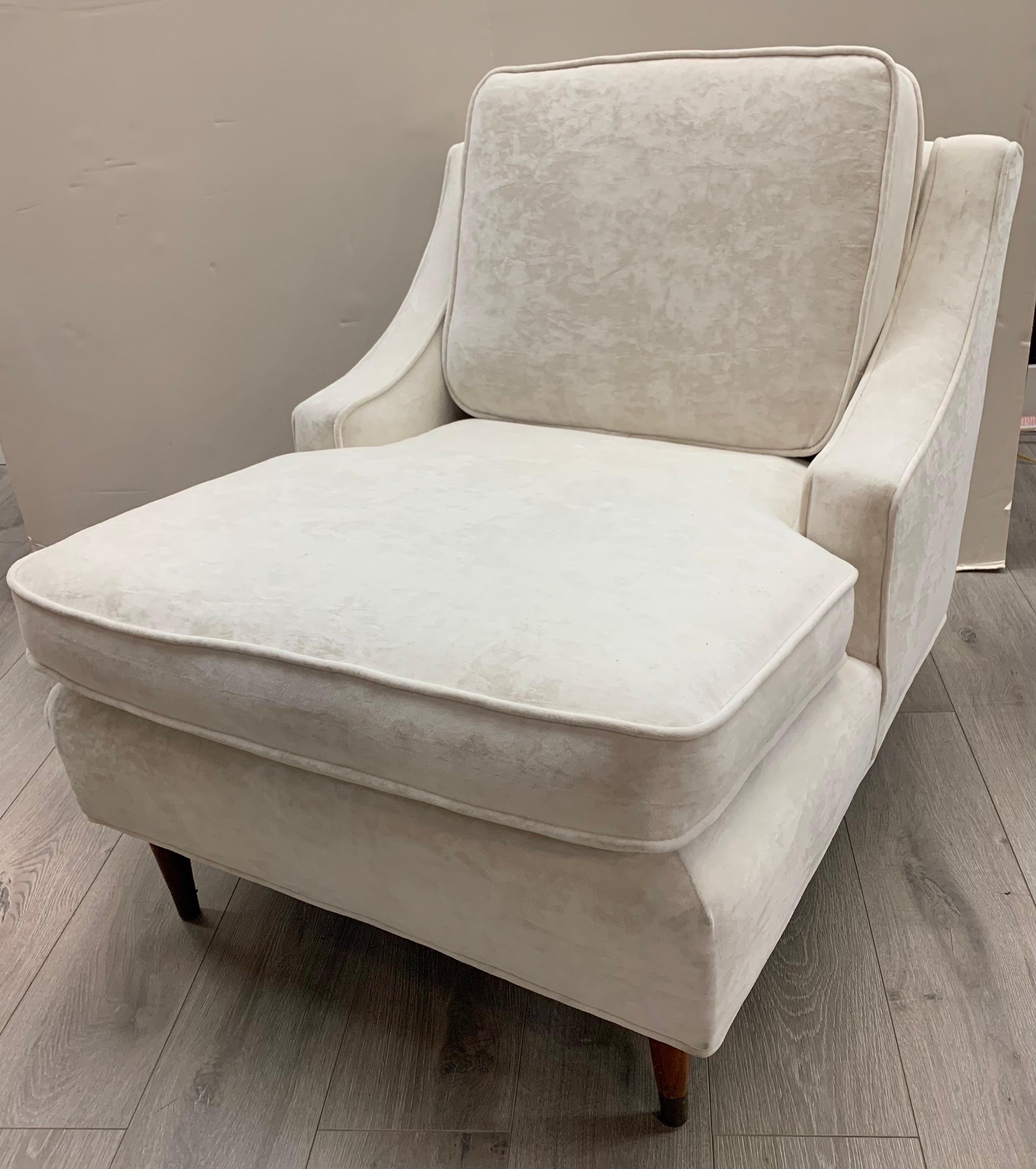 Pair of vintage mid century lounge chairs newly upholstered in an ivory colored crushed velvet upholstery.