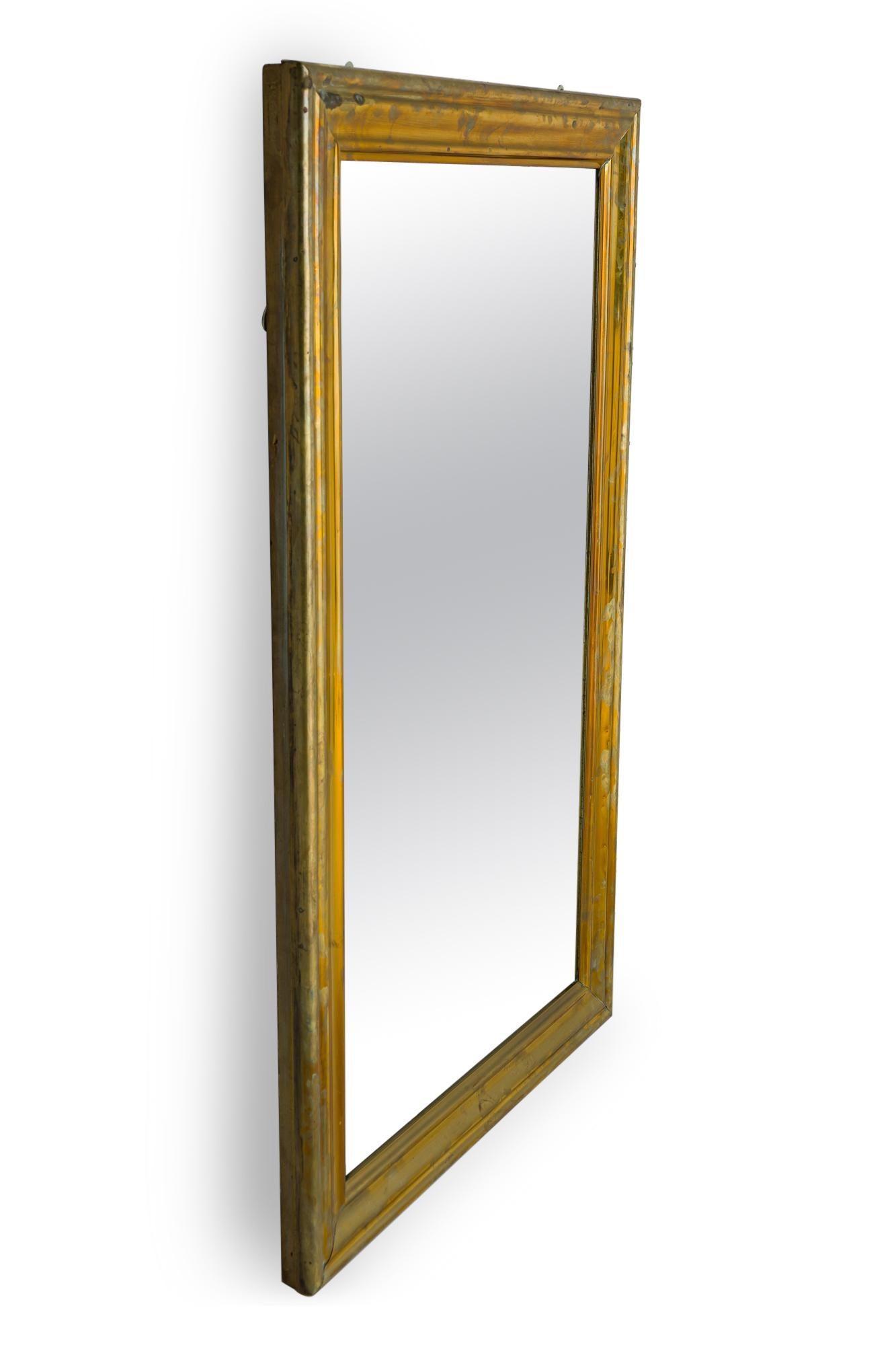 American Mid-Century bistro / wall mirror with a rectangular ogee frame finished with patinated brass veneer. (Similar mirror: DUA0024).