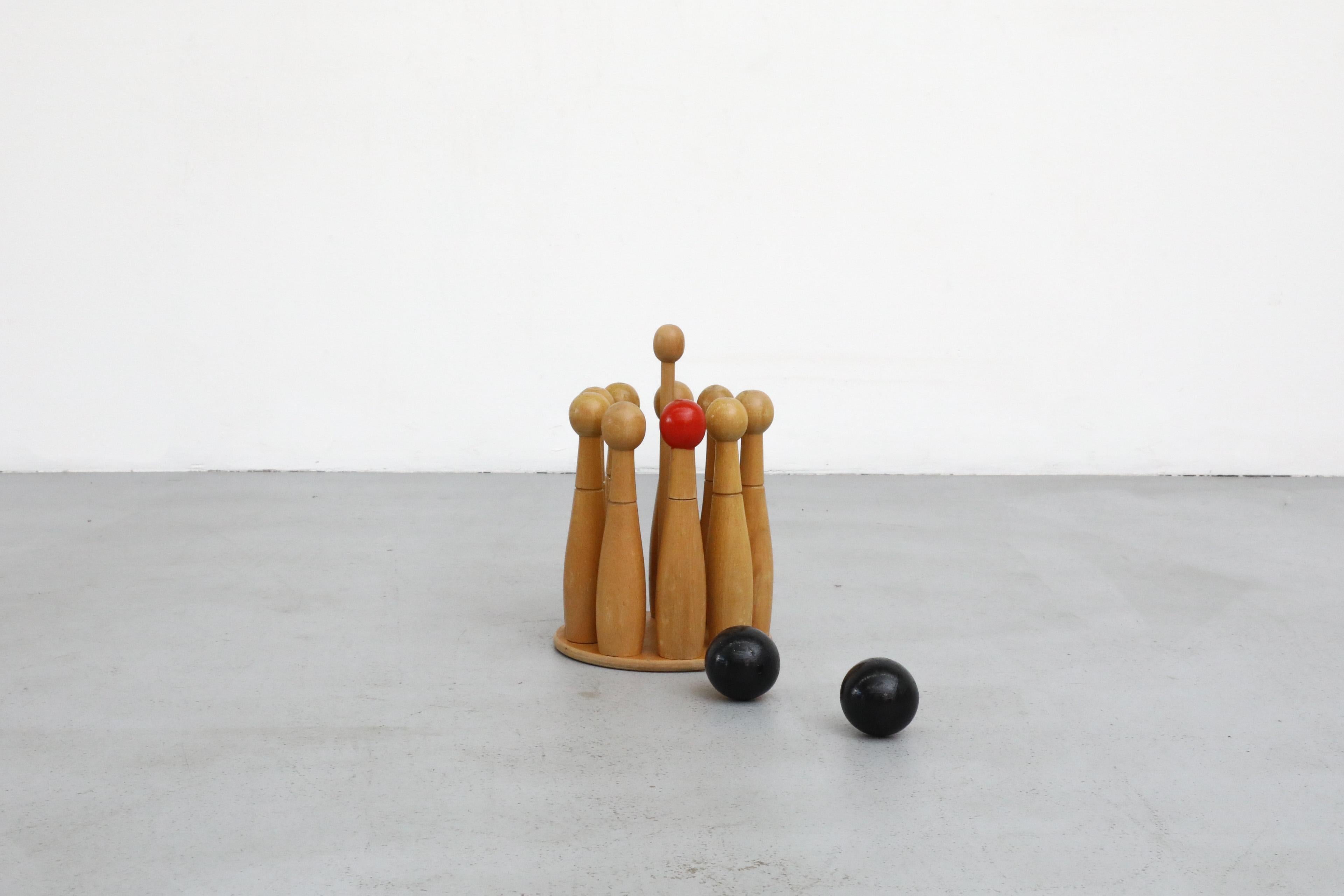 Jeu de quilles en bois à l'ancienne, datant du milieu du siècle dernier. Comprend 9 quilles, deux boules et son support d'origine. Le Skittles est un jeu de bowling de table originaire d'Europe qui a connu une grande popularité dans les îles