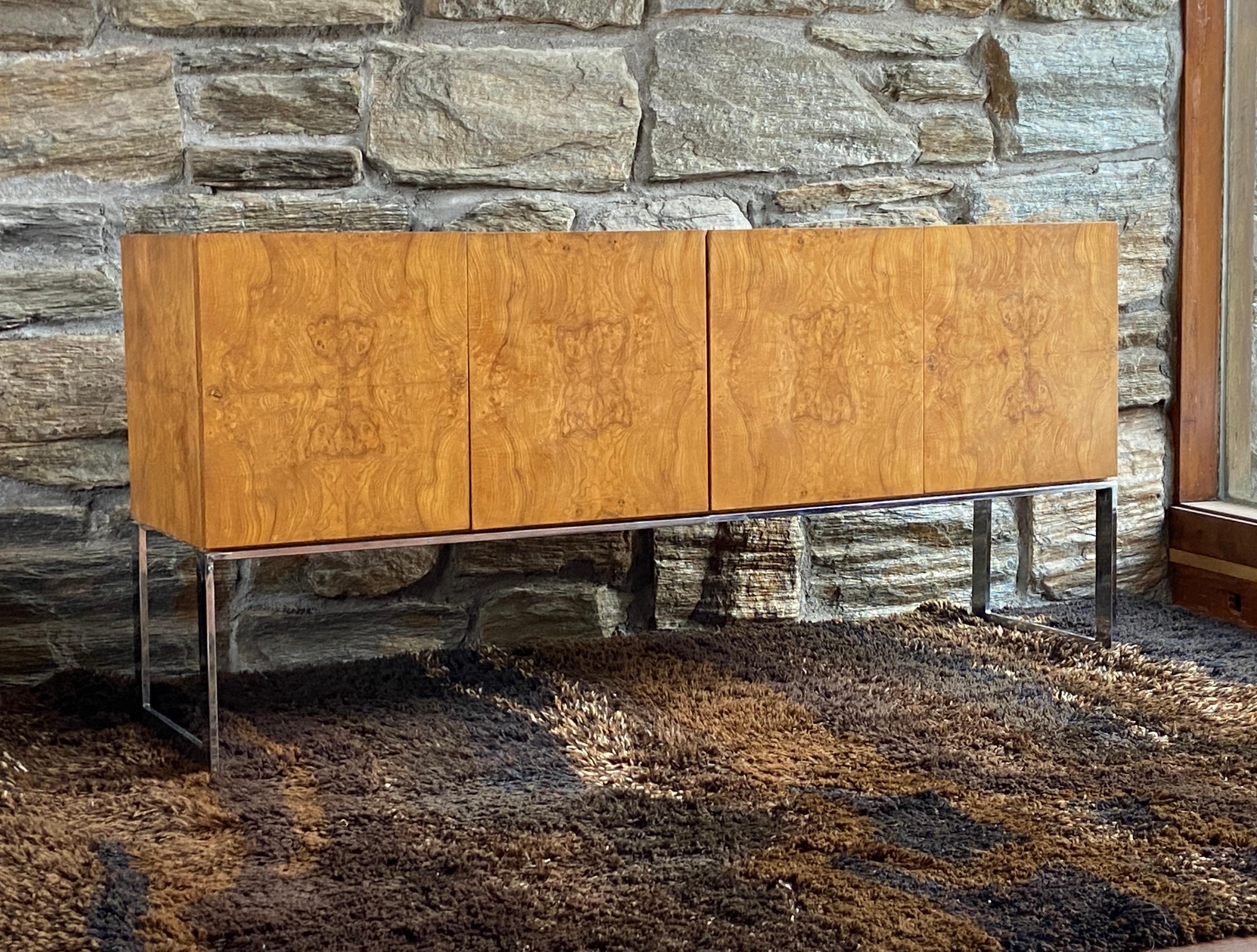 Beautiful olive burl credenza  with chrome base designed by Milo Baughman for Thayer Coggin. A classic design piece from the late 60's early 70's, with all book matched olive burl that creates a repeating pattern on front doors.   Nice vintage