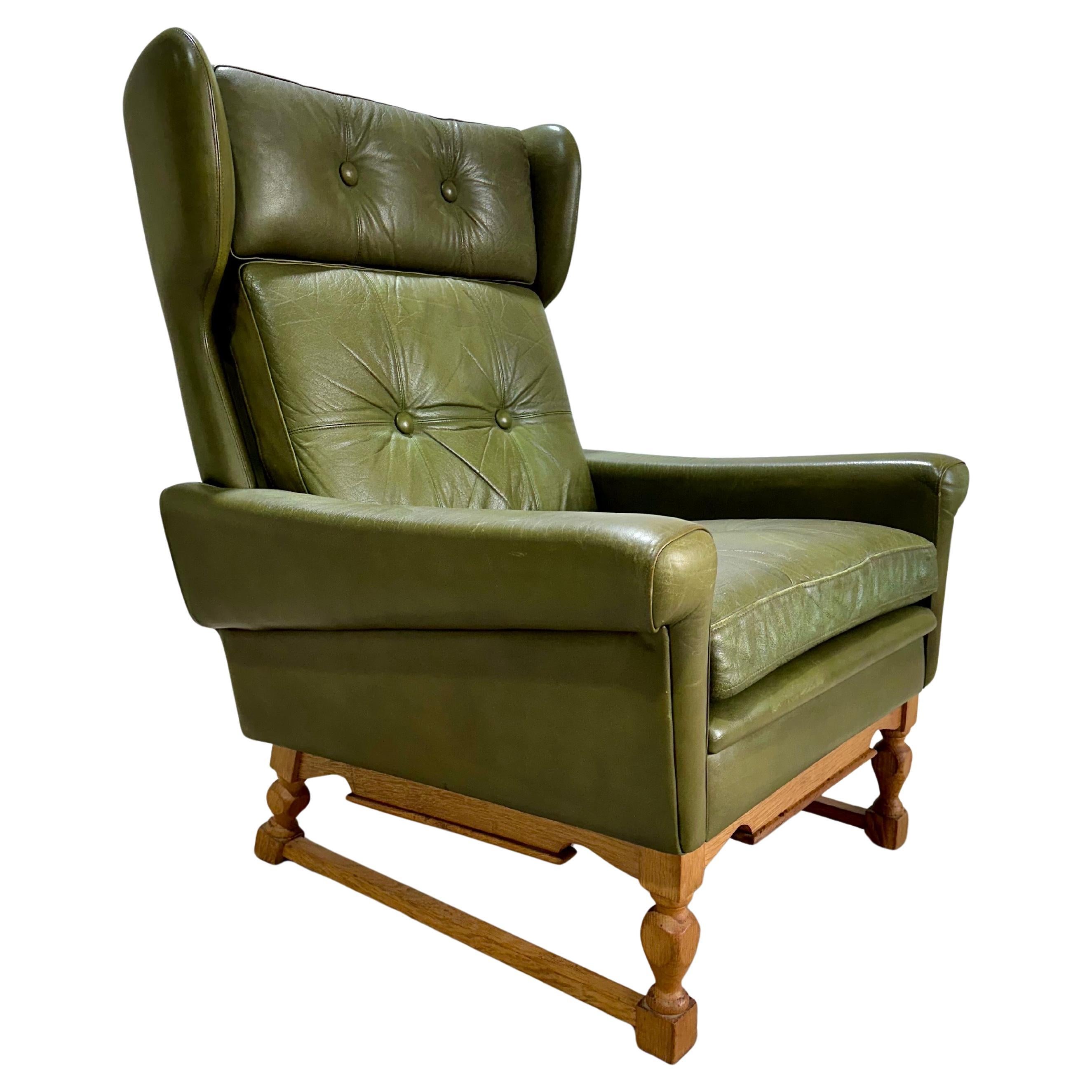 Vintage Mid Century Danish High Back Lounge Chair in olivgrünem Leder mit geschnitztem Kufengestell aus Eiche von Svend Skipper. Ein bequemer und attraktiver Stuhl mit Ohrenklappen-Flügelrücken-Details 

Vor kurzem aus Dänemark importiert. Insgesamt