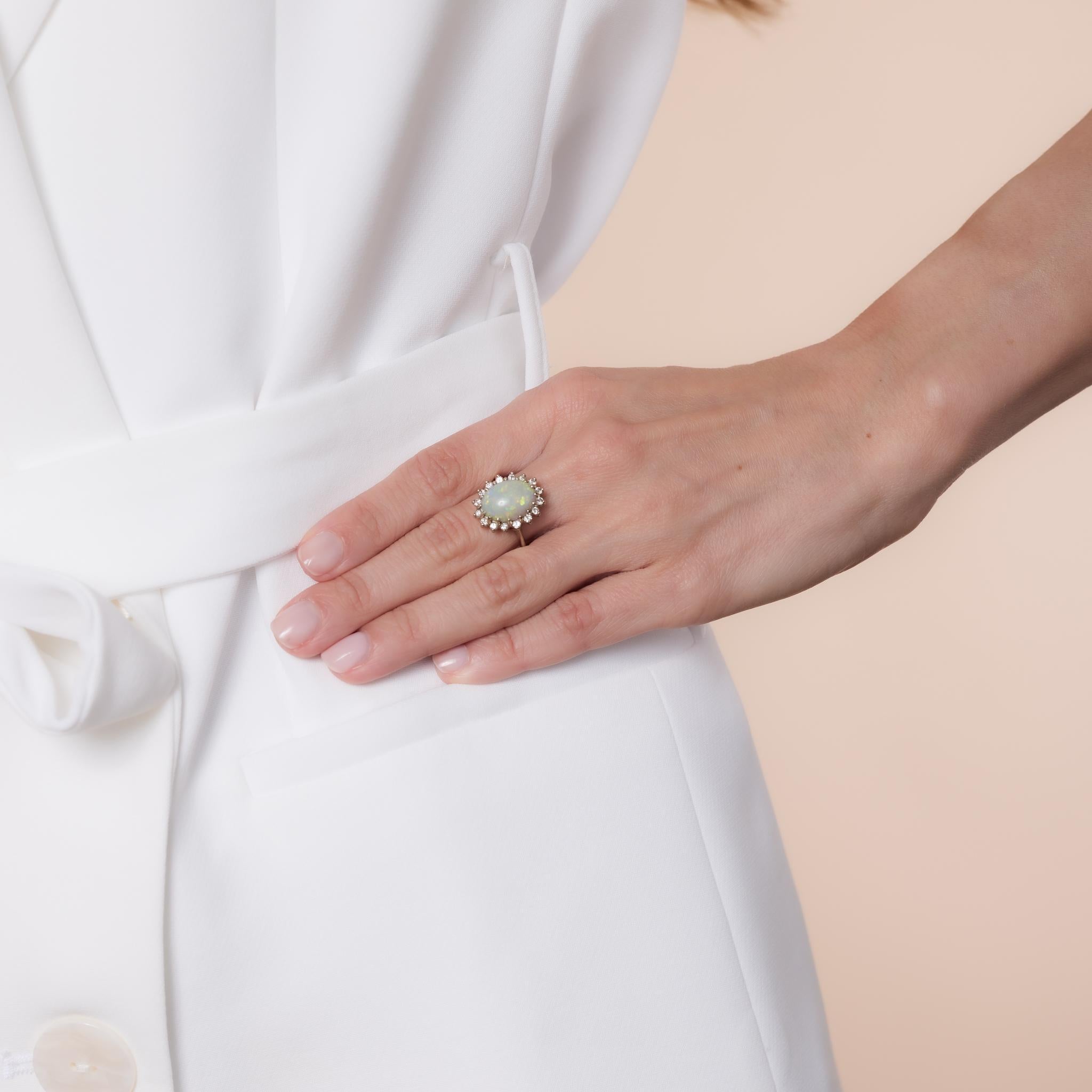 Mid Century 14k white gold halo ring featuring a luminous cabochon cut opal framed by sparkling diamonds. A timeless 1960s statement piece.

Center stone: Cabochon cut opal 
Size: Approximately 13.79mm x 10mm
Accent stone: 16 round brilliant cut