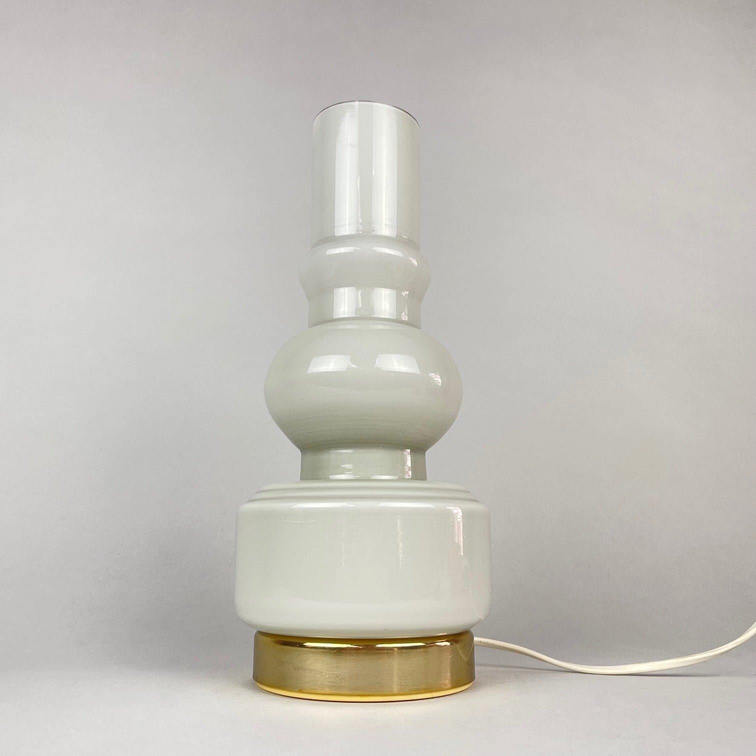 Rarely seen, vintage table lamp made of white opal glass. Brass plated finish. Original, fully functional wiring. Very good vintage condition. The brass top part is removable.
The lamp is approximately 33 cm (13 inch) high and 20 (7.88 inch) wide