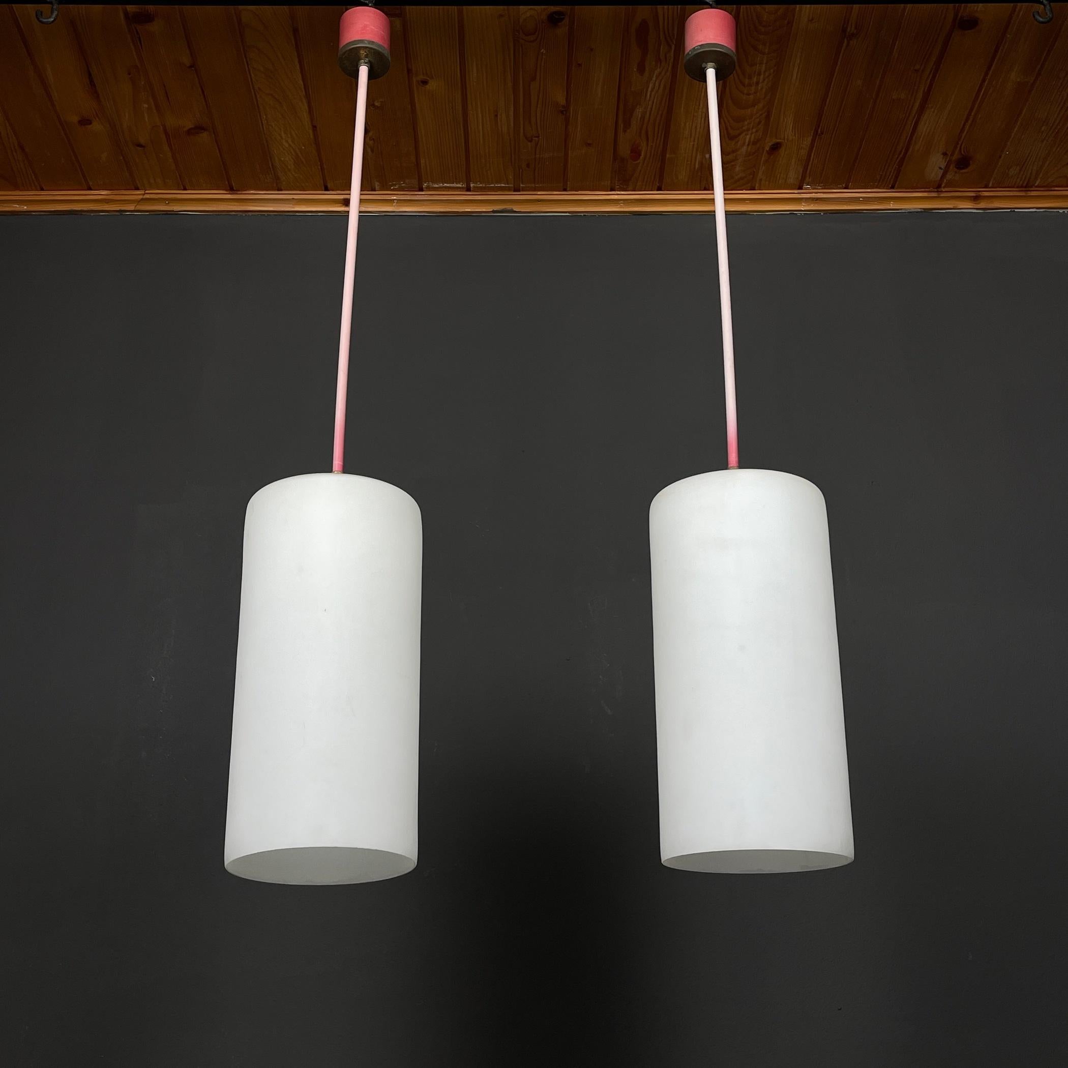 Step back in time with this remarkable set of two opaline glass pendant lamps, a testament to the mid-century era's design brilliance. Crafted in Italy during the 1960s, these lamps emanate industrial Italian lighting charm. The opaline glass shades