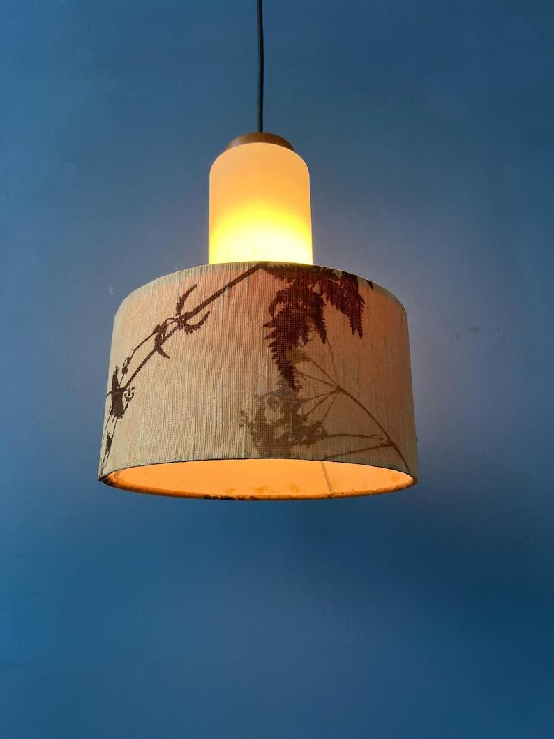 Lampada a sospensione danese in vetro opalino con paralume a motivi tessili Jungling. Il bagliore emesso dal vetro al latte si riflette piacevolmente attraverso il tessuto beige. La lampada richiede una lampadina E27/26 (standard).

Informazioni