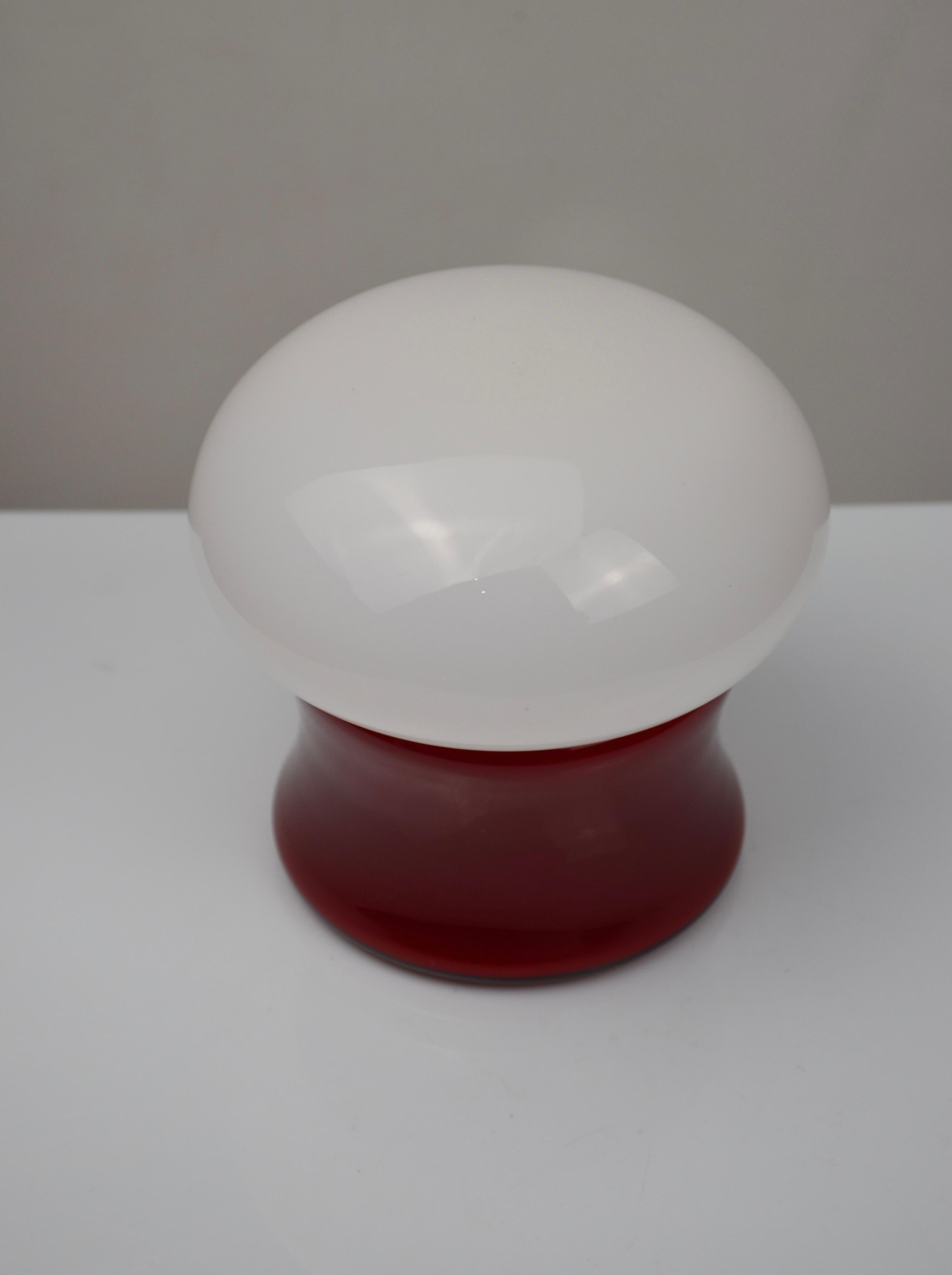 Encantadora lámpara vintage con forma de seta de los años 60, totalmente de cristal opalino. El globo de opalina blanca proporciona una luz suave y difusa, bellamente complementada por su base esculpida de opalina roja.
Esta lámpara presenta una