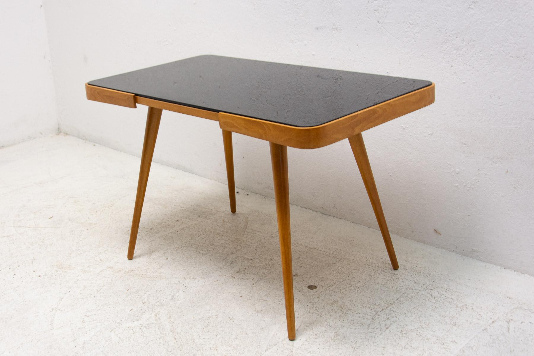 Mid century opaxite glass coffee table from the 1960´s. Associated with the world-renowned exhibition EXPO 58 in Brussels. It was produced by “Interiér Praha”. It features a beechwood structure and a black glass tabletop. In very good Vintage