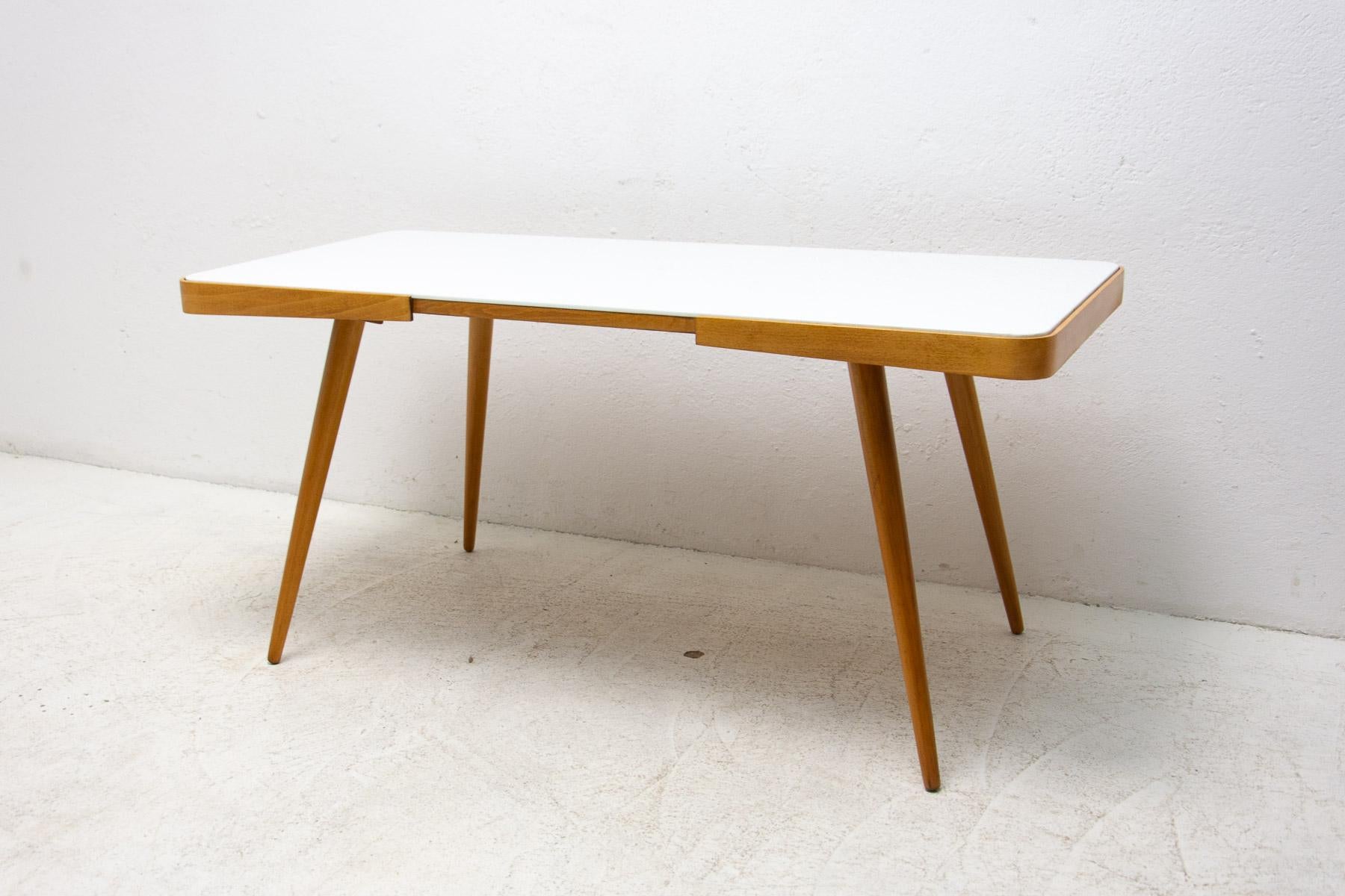 midcentury opaxite glass coffee table from the 1960´s. Associated with the world-renowned exhibition EXPO 58 in Brussels. It was produced by “Interiér Praha”. It features a beechwood structure and a white glass tabletop. In good Vintage condition,