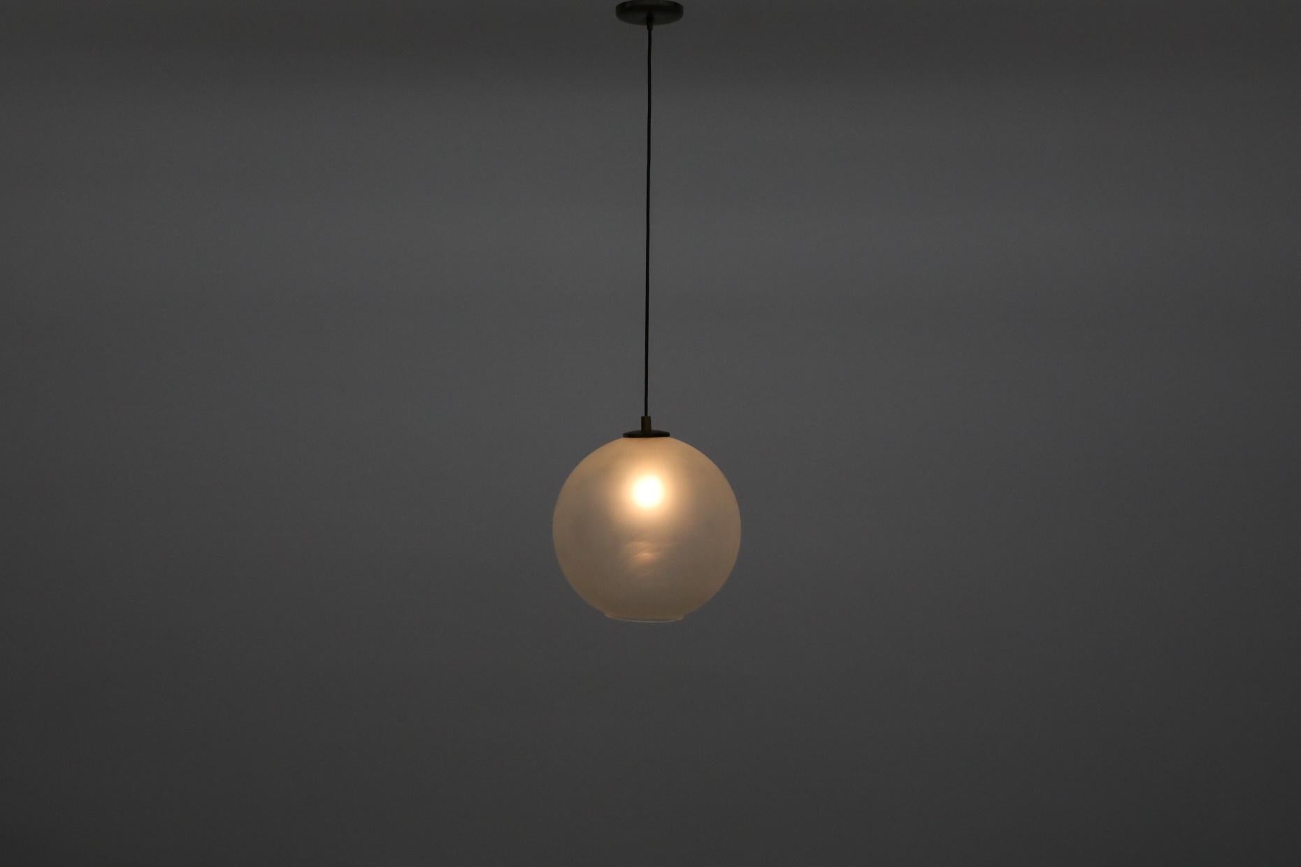 Globe en verre dépoli du milieu du siècle, avec un fond ouvert et des ferrures en laiton. En état d'origine avec des accents en laiton patinés. L'usure est conforme à l'âge et à l'utilisation.