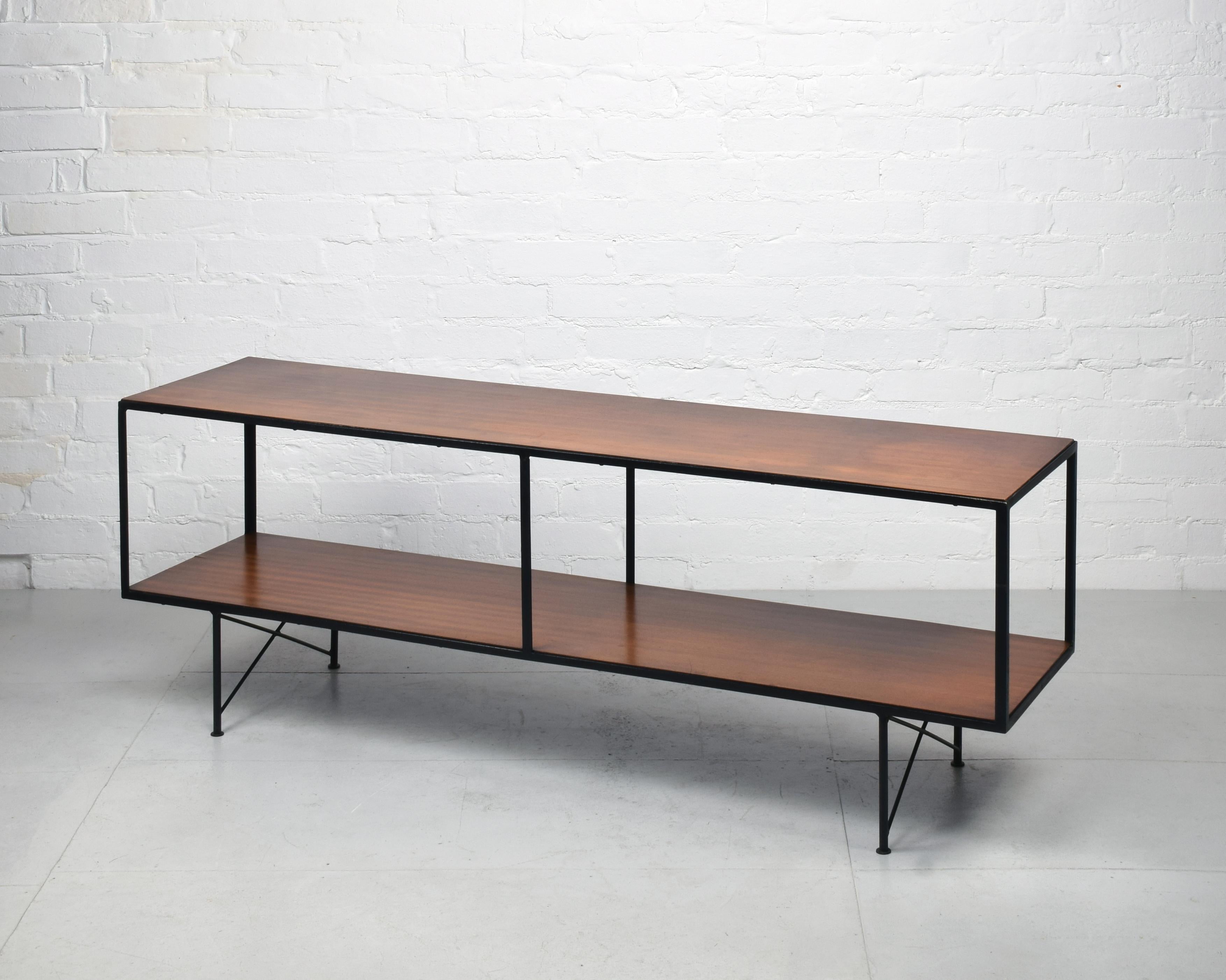 Mid-century open-framed unit, c. 1950s / 1960s

Black metal frame, teak veneered wood.

Good original condition. This is unrestored, so maintains various marks and imperfections that we feel gives it character.

A beautiful peice, this works well as