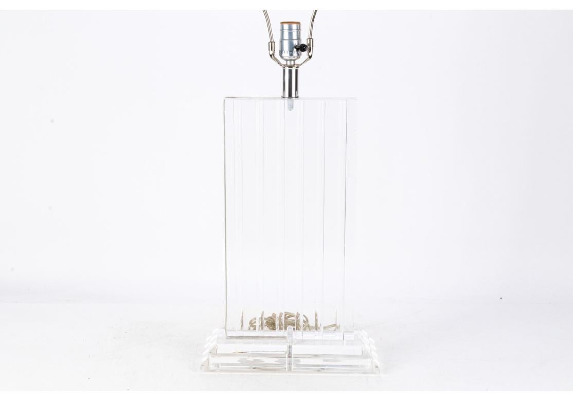 Una lampada da tavolo in lucite degli anni '70 con una forma particolarmente raffinata di un blocco rettangolare con mezze aste incise che corrono verticalmente.  un effetto ottico di grande impatto e l'aggiunta di movimento al blocco trasparente.