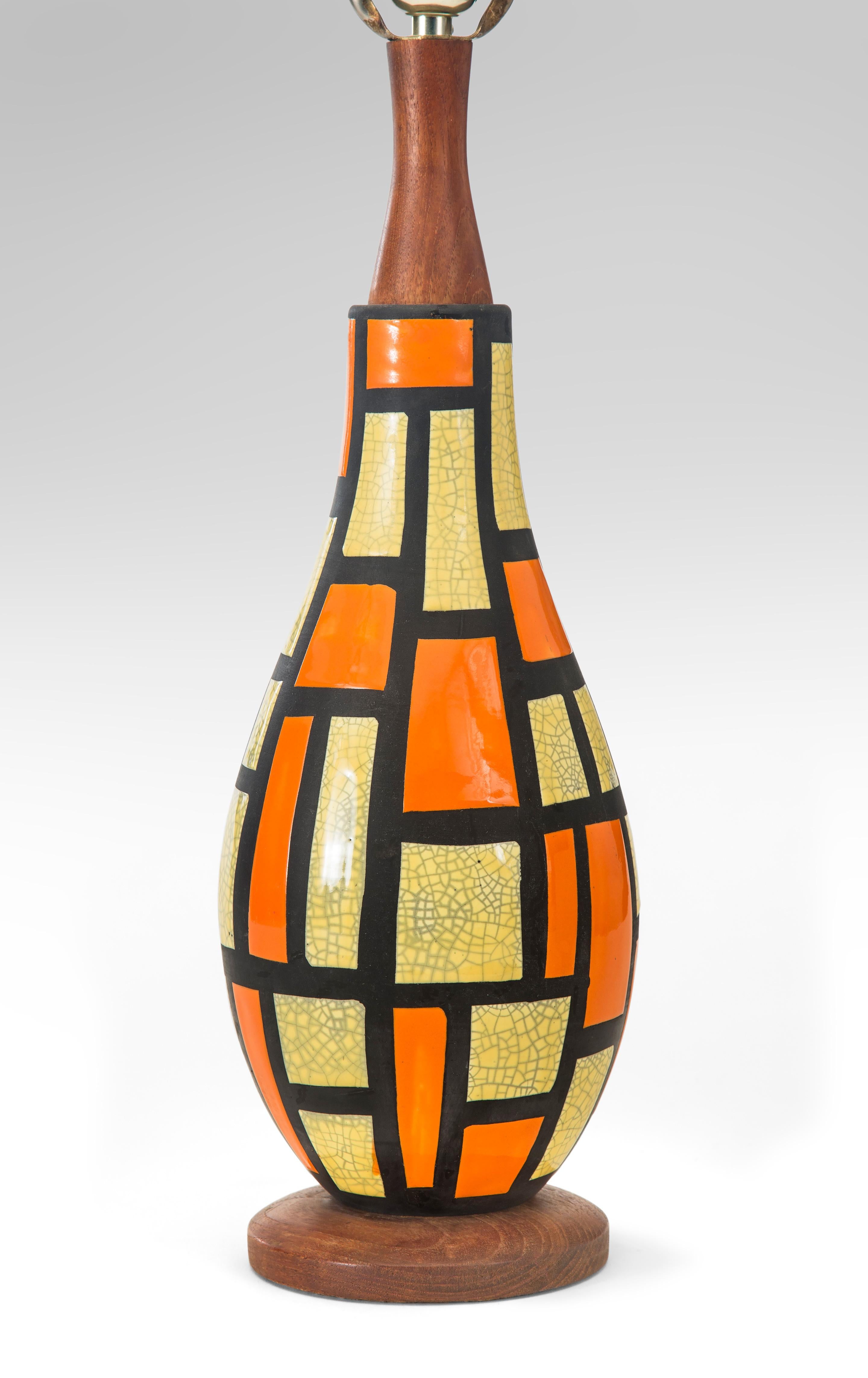 Midcentury orange and yellow ceramic lamp,
circa 1950
This lamp with its bright colors arranged in an irregular grid defines mid century modern. The bottle-shaped vase with a craquelure glaze of a colorful patchwork design. This lamp will add joy