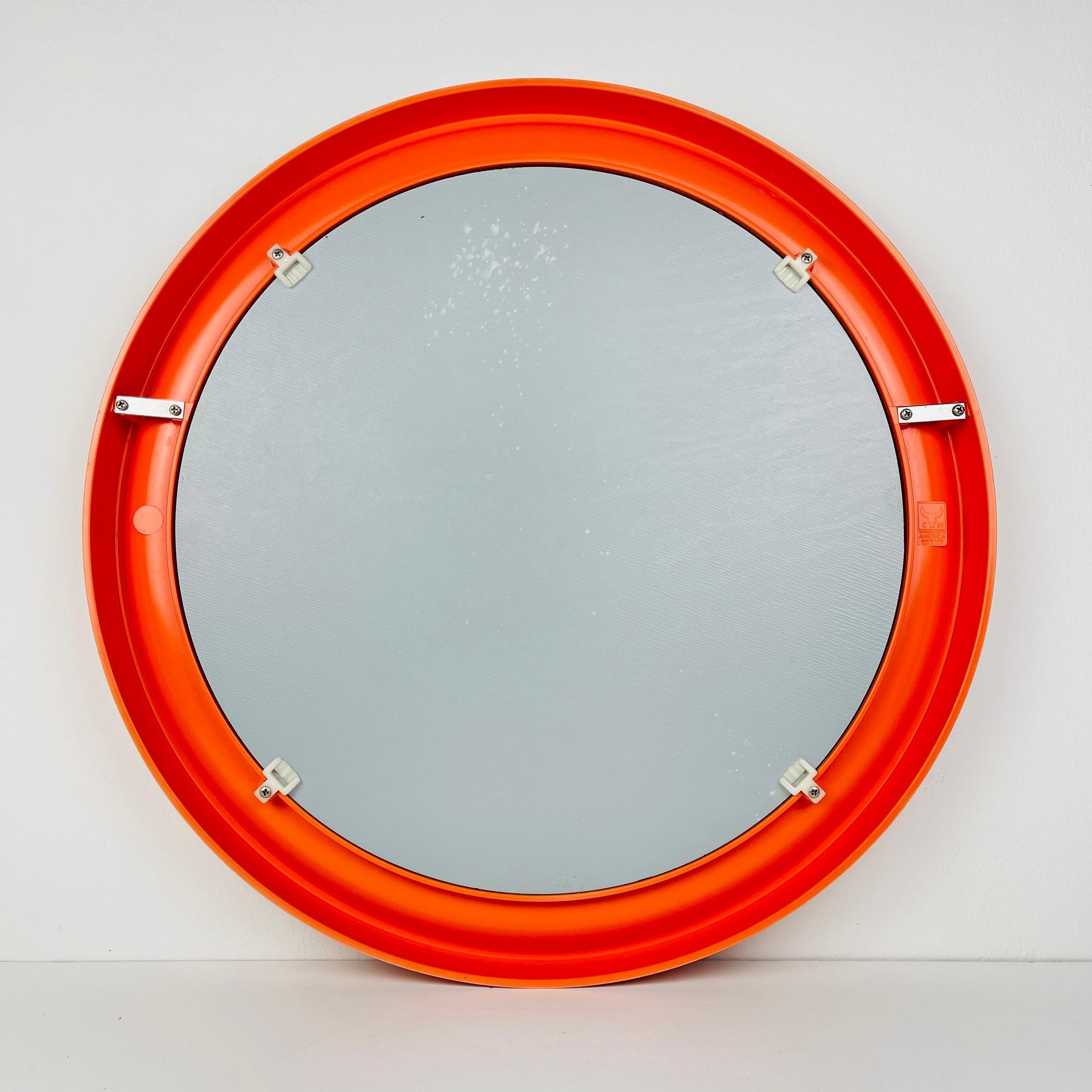 Add a pop of retro charm to your space with this exceptional orange bakelite mirror, crafted in Italy during the 1970s by Carrara & Matta under the model name 