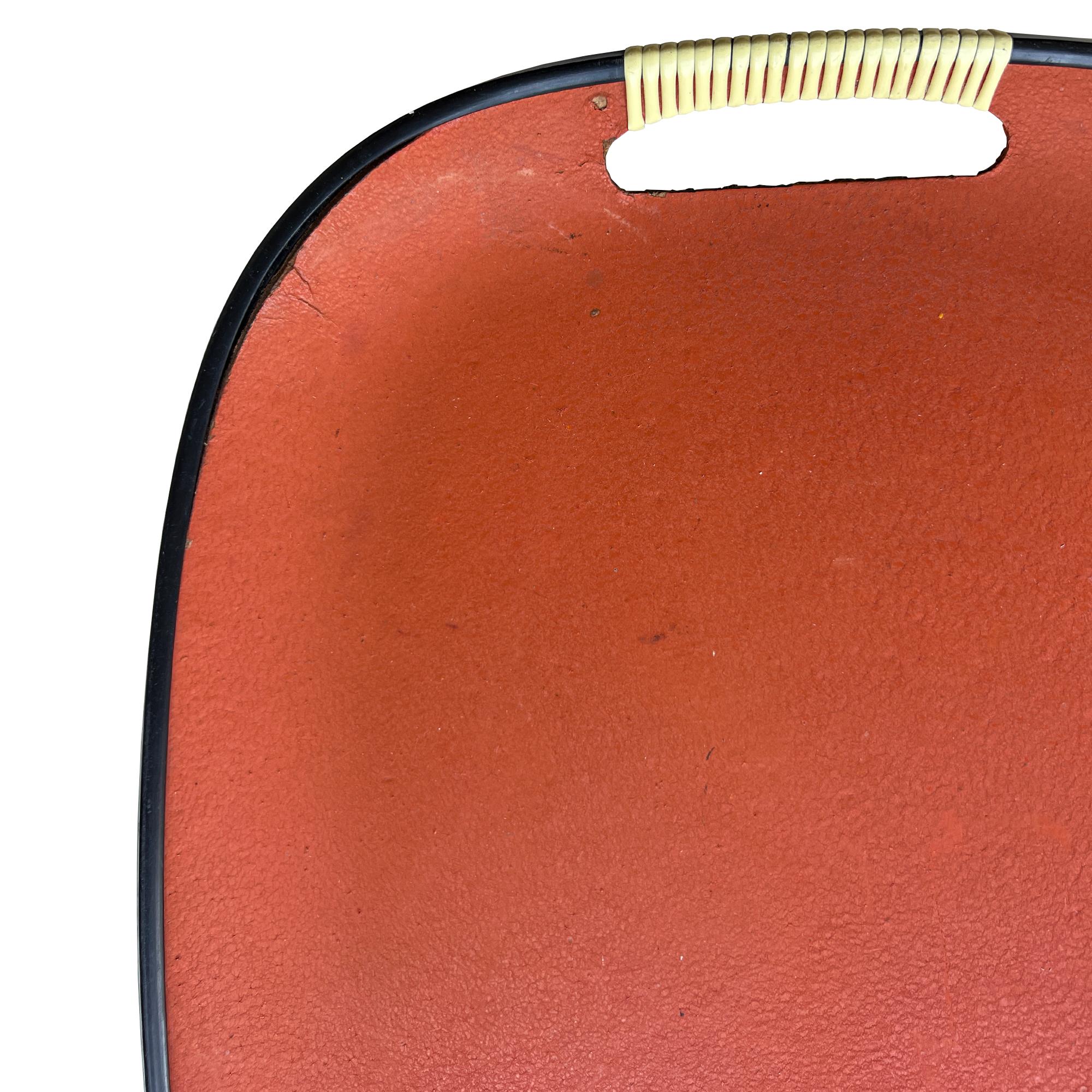Dieses Serviertablett aus der Mitte des Jahrhunderts setzt einen kräftigen Farbakzent auf Ihrem Barwagen oder Couchtisch. Es zeigt ein sattes Hermès-Orange, das von einem schmalen schwarzen Rand umrahmt wird, und hat elfenbeinfarbene, gerippte