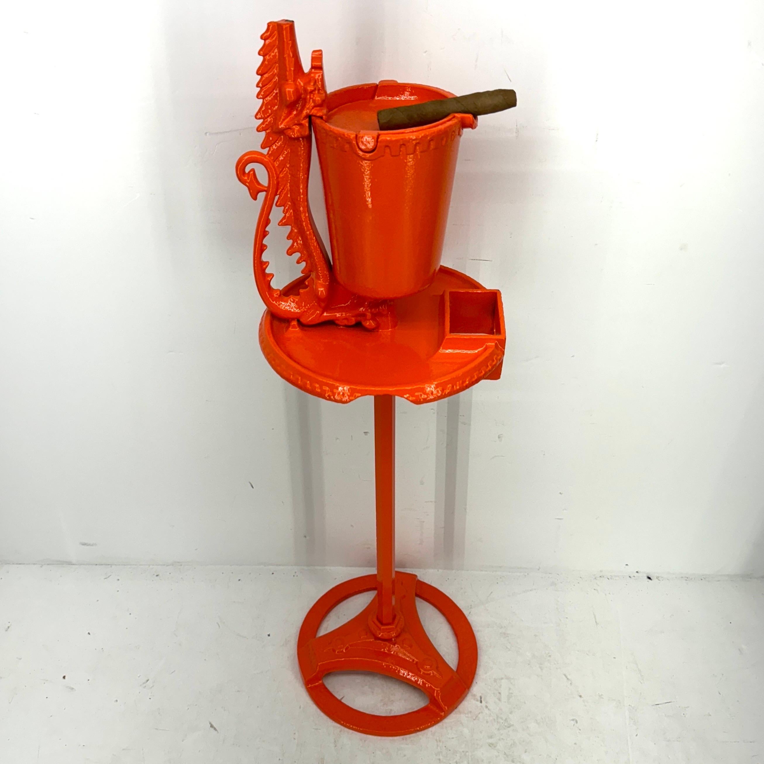 Mid-Century Modern iron ashtray. Feast your eyes on this beautiful floor ashtray. Even if you are not a smoker, this beautiful cast iron floor statue is graced with a dolphin or mythical animal at the top and is as comfortable holding fireplace