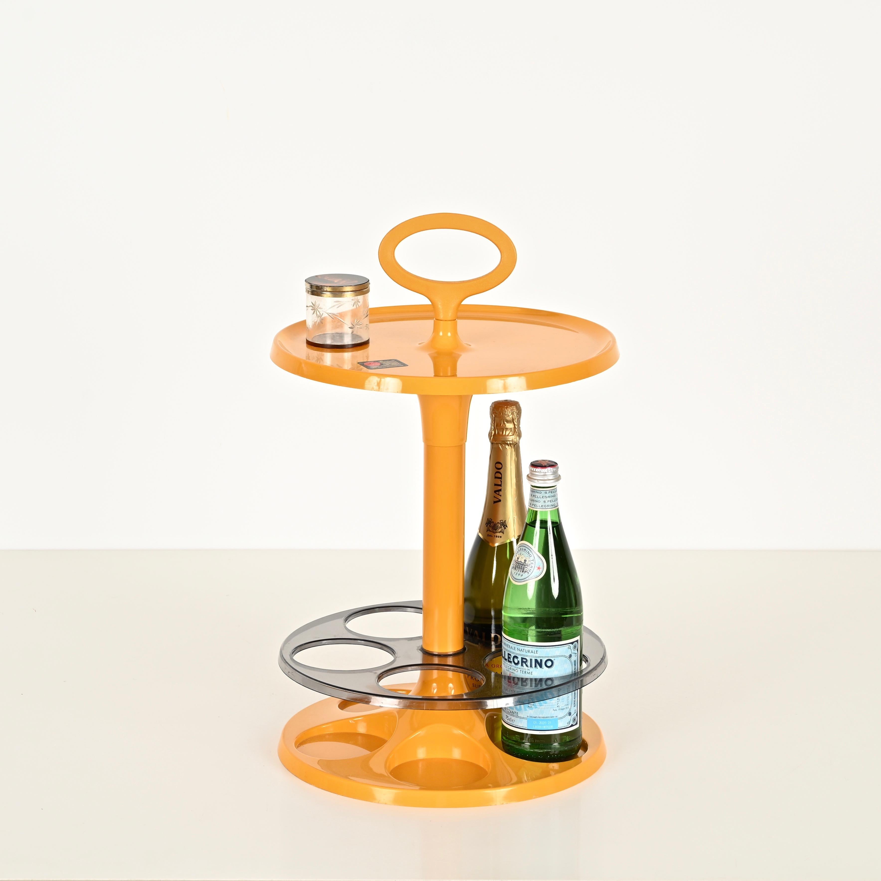 Verspielter und funktioneller Beistelltisch aus der Mitte des Jahrhunderts mit Flaschenhalter aus einem schönen, leuchtend orangefarbenen Abs-Kunststoff und geräuchertem Lucite. Dieser stilvolle kleine Tisch wurde in den 1970er Jahren von Flair in