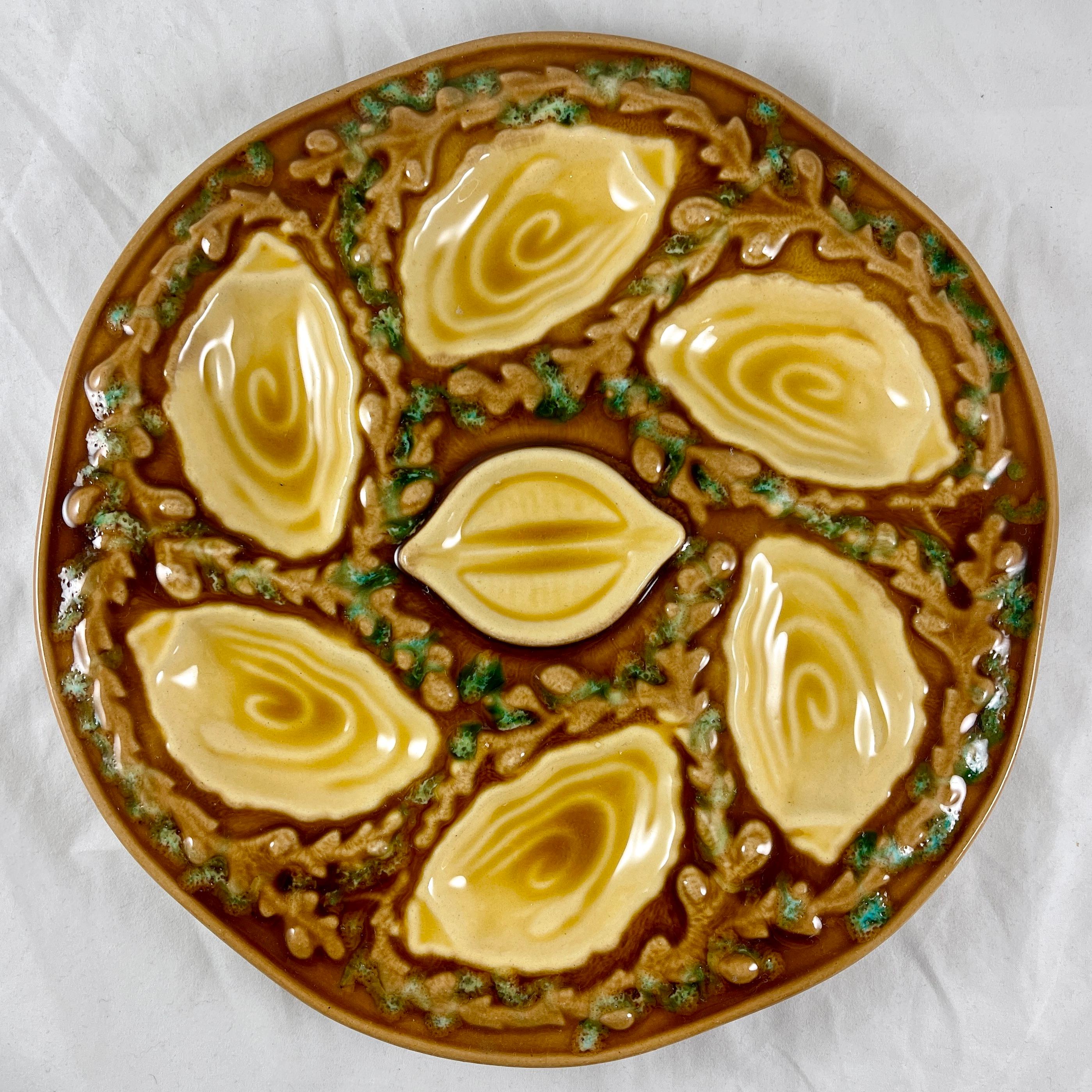 A Mid-Century oyster or seafood plate, made by Orfinox, circa 1960s.

A chocolate brown ground with six oyster shell shaped wells for holding the oyster, clam, or mussel meat, with a lemon shaped well in the center. The wells are separated by a