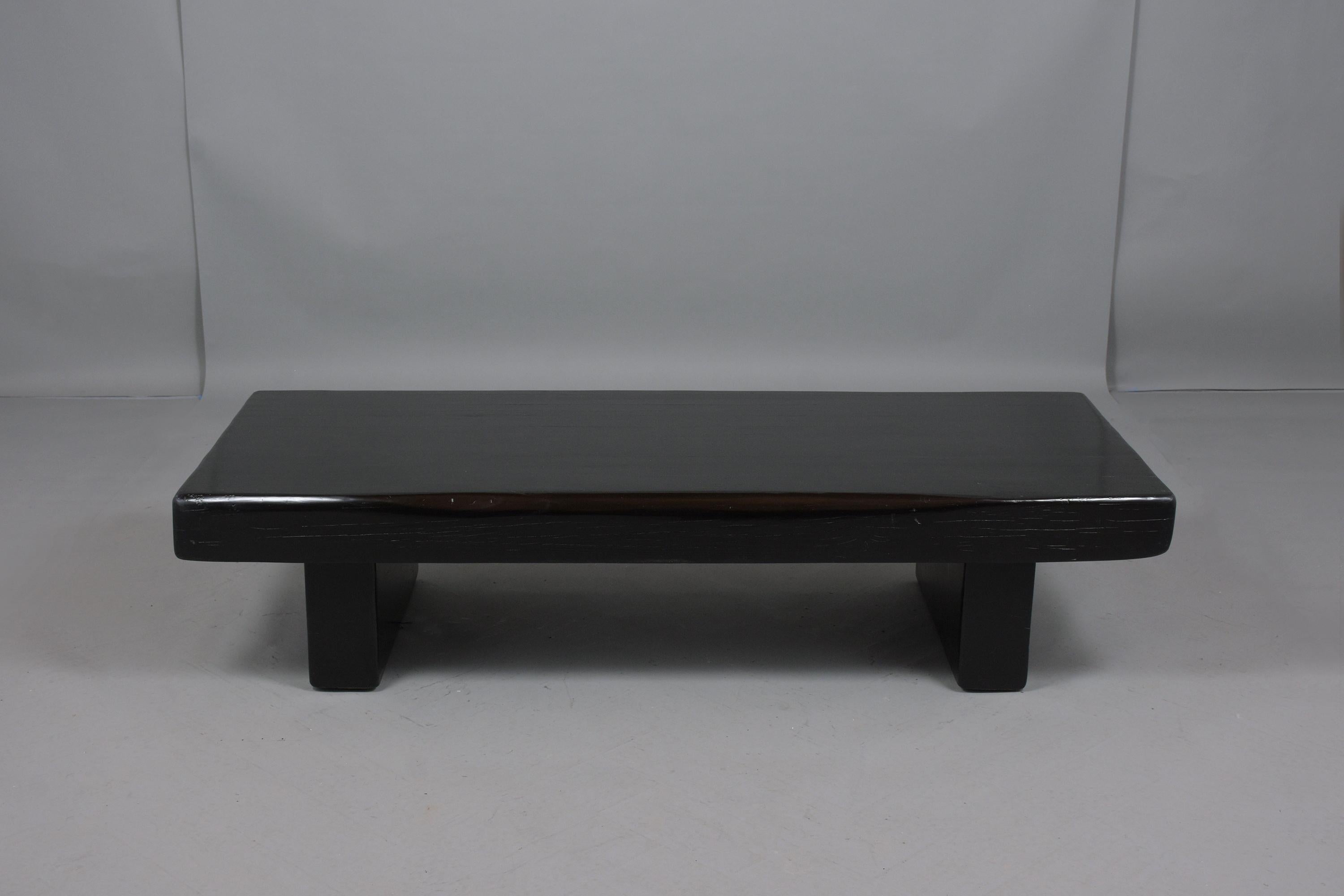 An excellent coffee table hand-crafted out of solid wood with a simple form design that sits on sturdy block pedestal legs. This fabulous piece has newly finished in deep black color with lacquered finish a perfect and will make the perfect addition