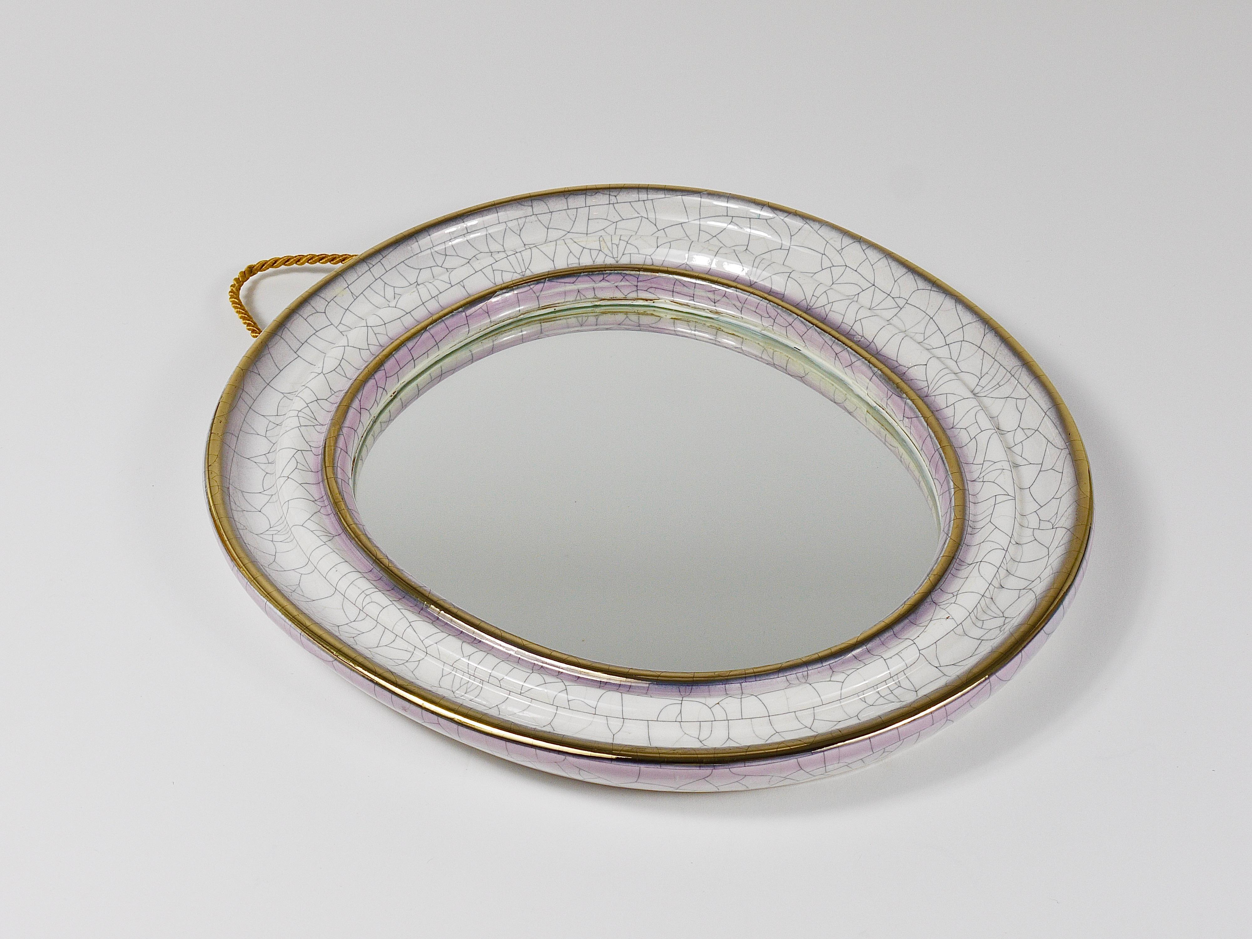 Ein charmanter, organisch geformter Wandspiegel aus den 1950er Jahren, hergestellt von Gmundner Keramik in Österreich. Der Rahmen ist aus Keramik/Töpferware mit einer wunderschönen weißen Craquelé-Glasur und einer goldenen Zierlinie, die ihn umgibt.
