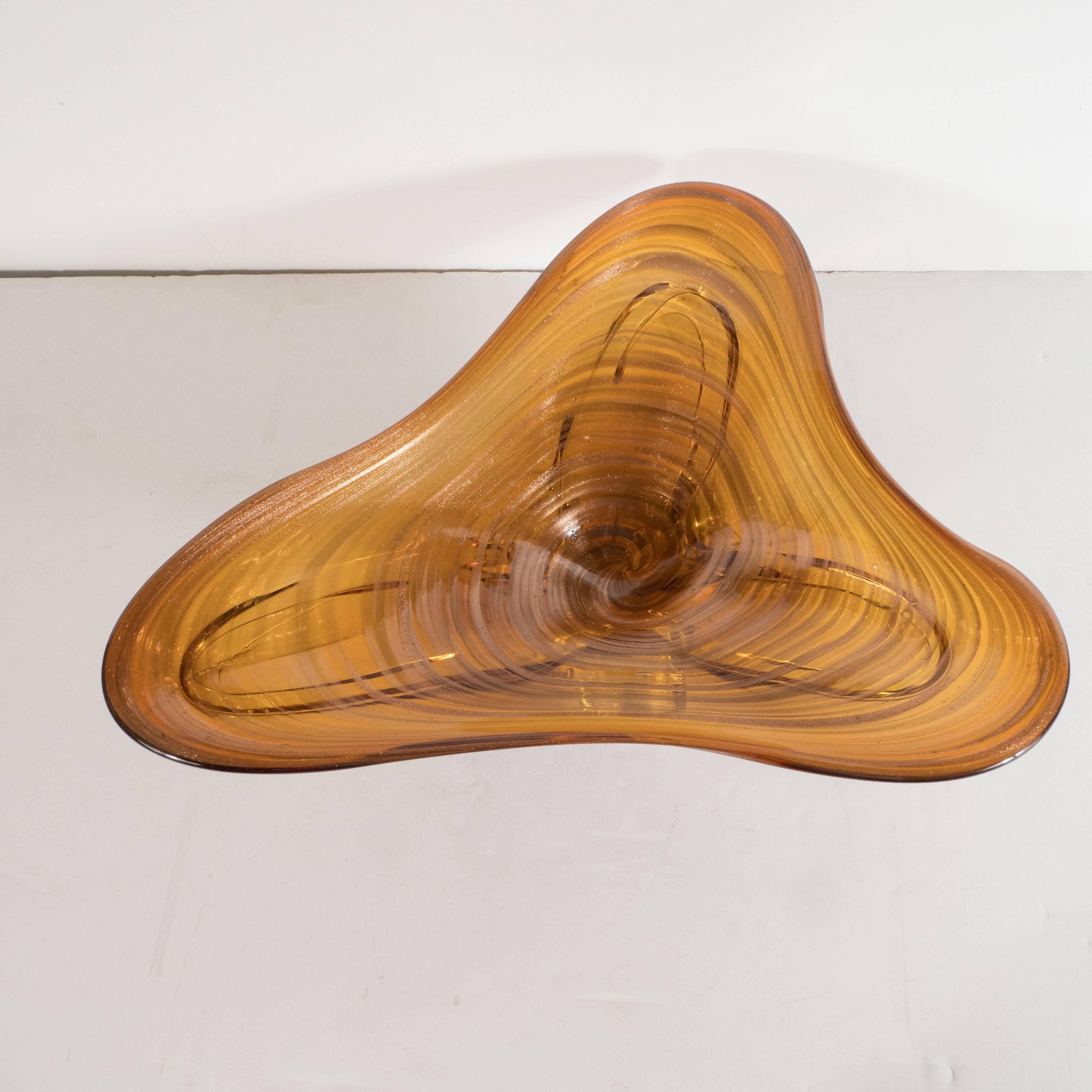 This stunning Mid-Century Modern handblown glass bowl was handblown in Murano, Italy, the islands off the coast of Venice renowned for centuries for its superlative glass production, circa 1960. It features a swirling pattern replete with an