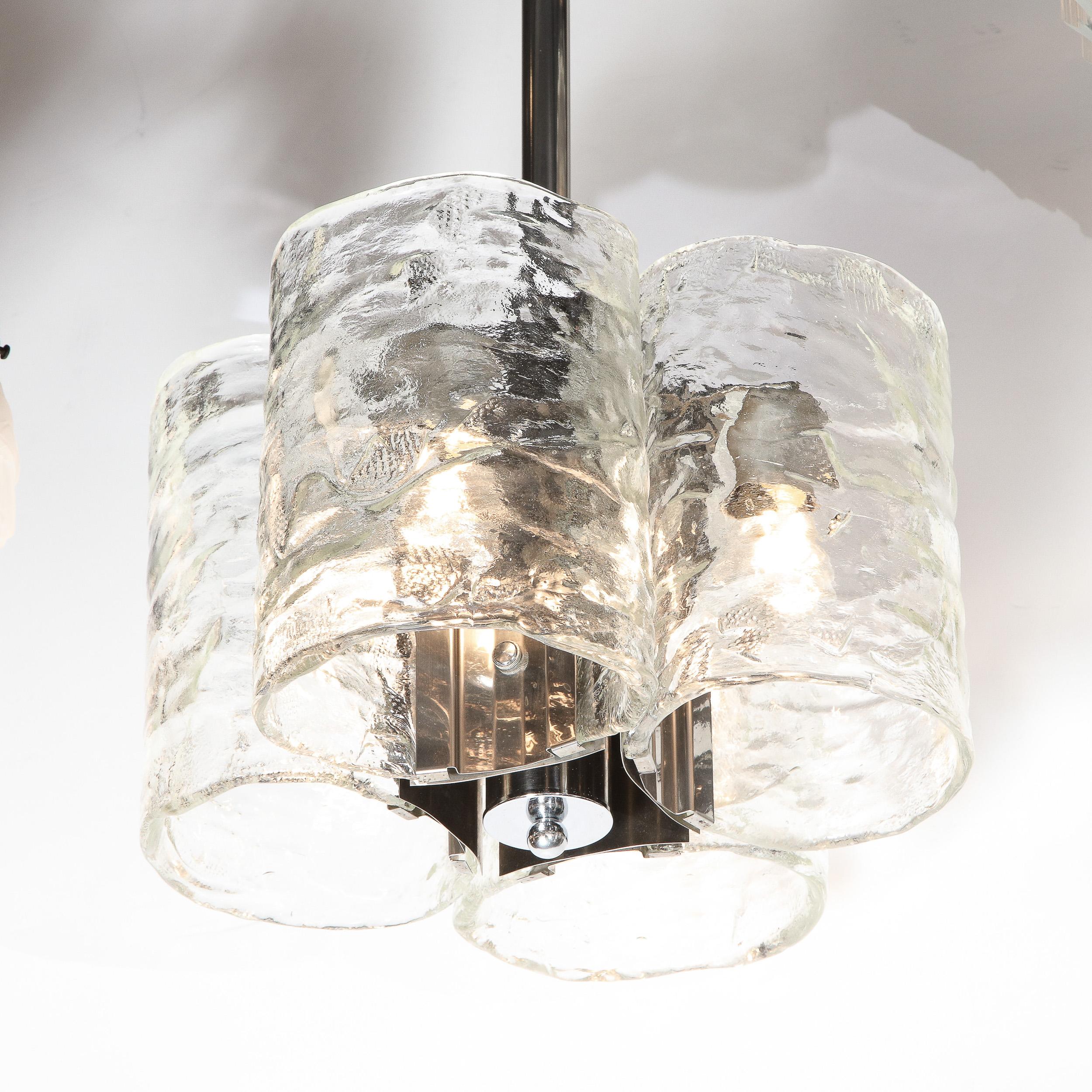 This handsome Mid-Century Modern chandelier was realized by the celebrated Italian design firm, Mazzega, circa 1970. It features four oblong cylindrical forms in translucent smoked Murano glass with a subtle organic texture affixed to a cylindrical