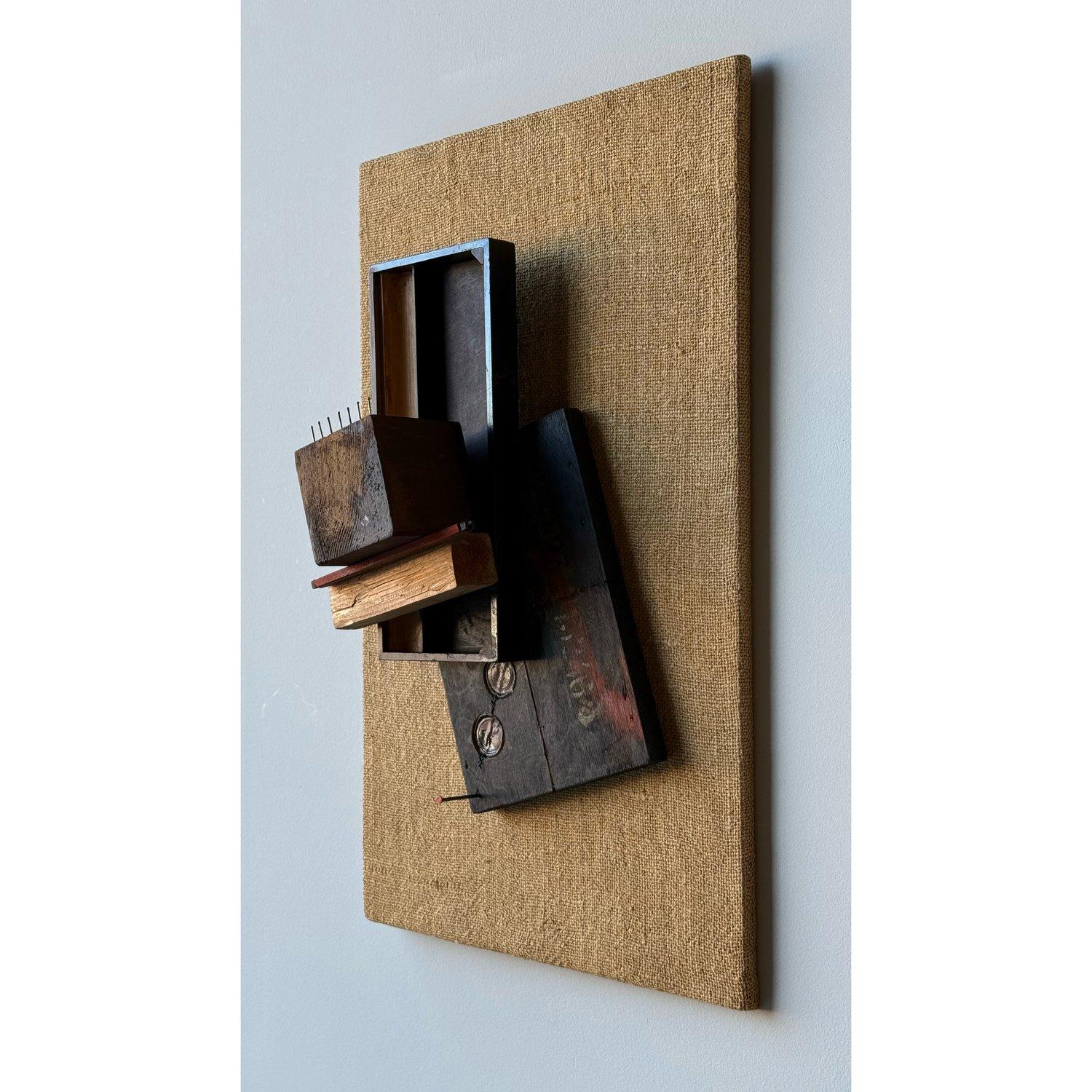 Original sculptural wall art by artist Jean Olds. Brutalist in style and construction against a burlap background. Mixed media, combining various wooden elements and nails. The composition is abstract, with different pieces of wood layered and