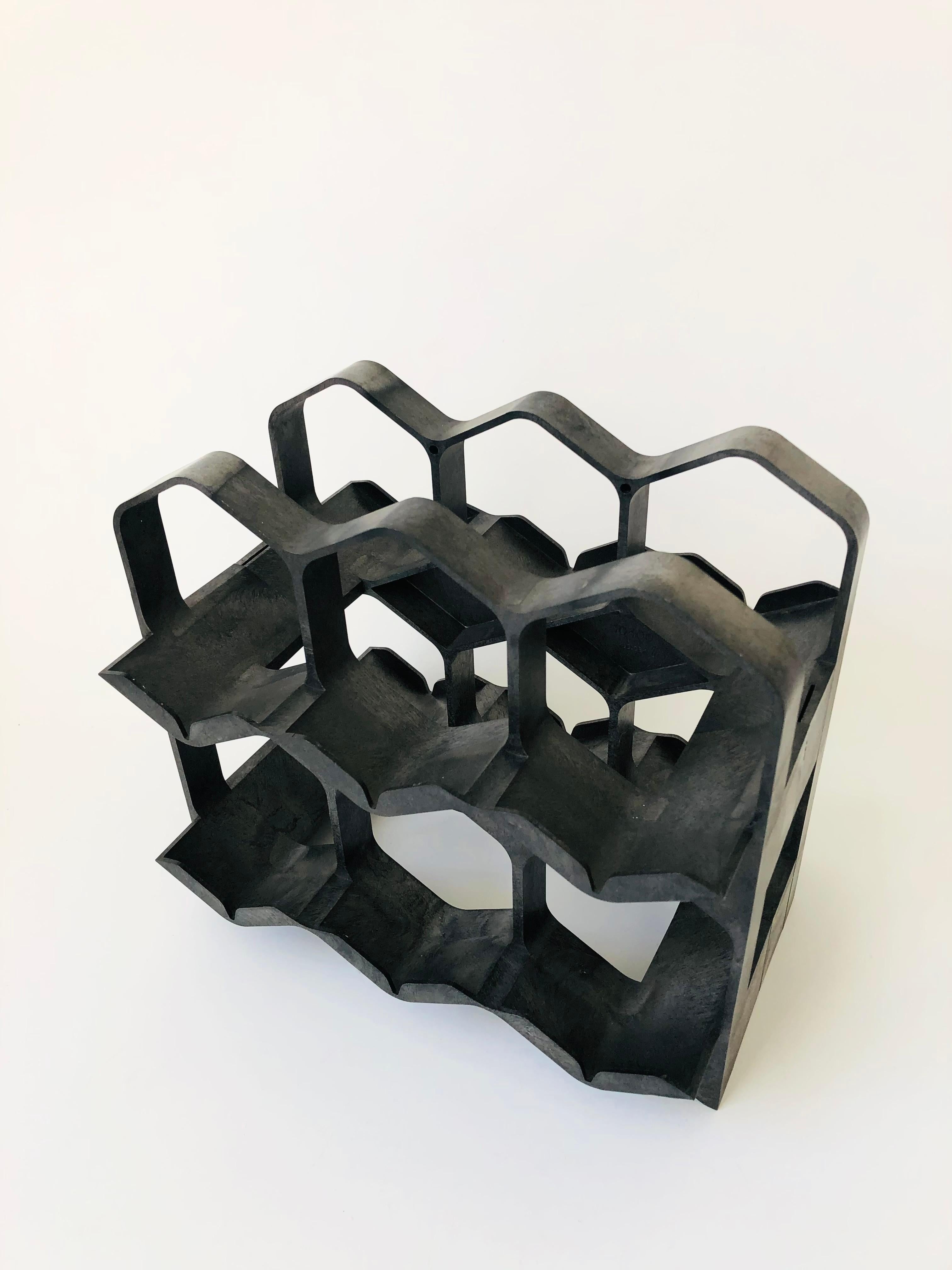 A wonderful mid century wine rack. Made of dark gray molded plastic with a unique variation to the coloring. Great honeycomb design that can hold up to 6 bottles. Made in Switzerland by Ornapress.

