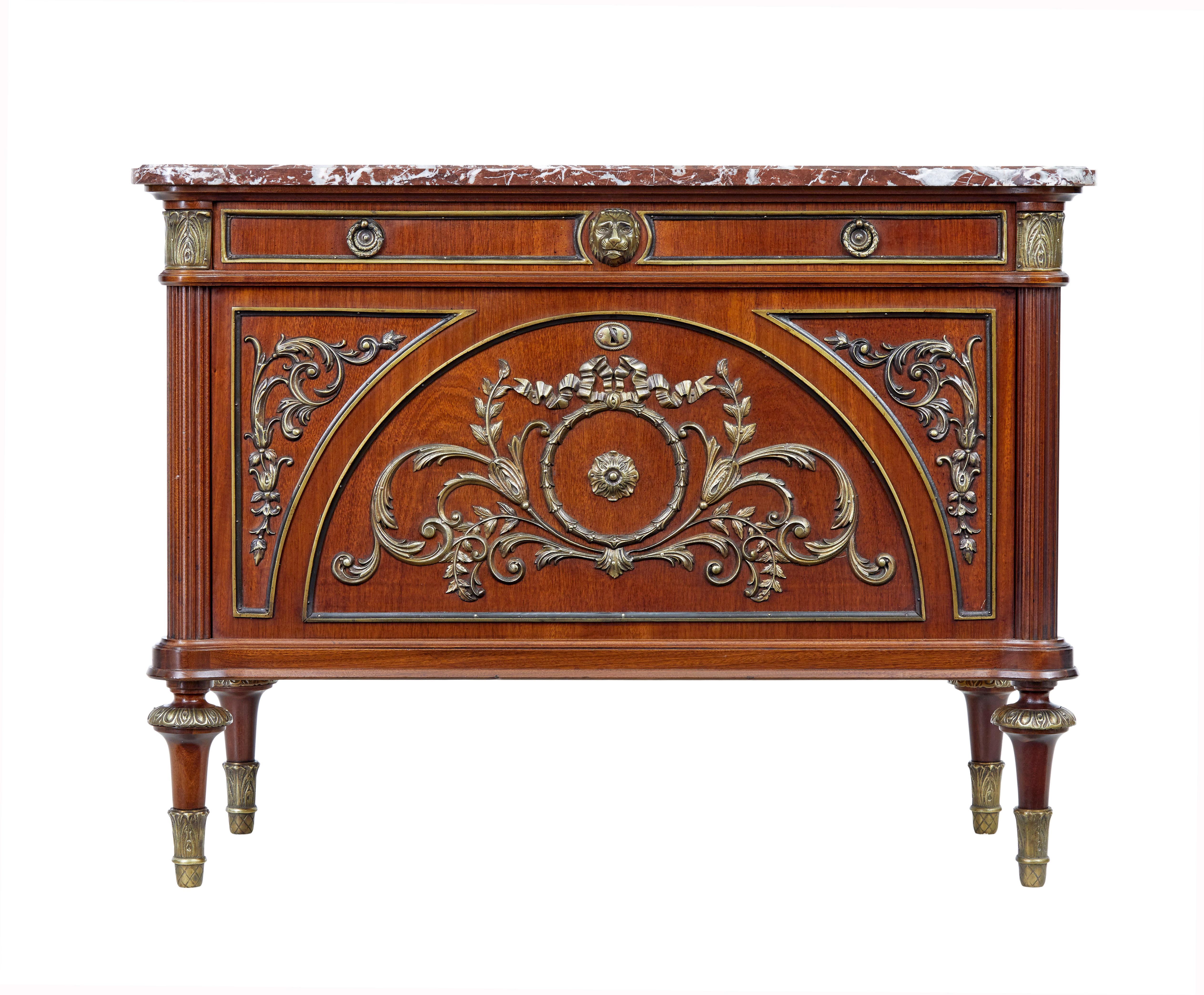 Commodo di qualità degli anni '60 con piano in ormolu, mogano e marmo.

Un cassetto singolo sotto il piano, con un frontale a ribalta che nasconde 2 cassetti a incastro. Decorazioni in ottone e ormolu' splendidamente applicate. Colonne scanalate ai