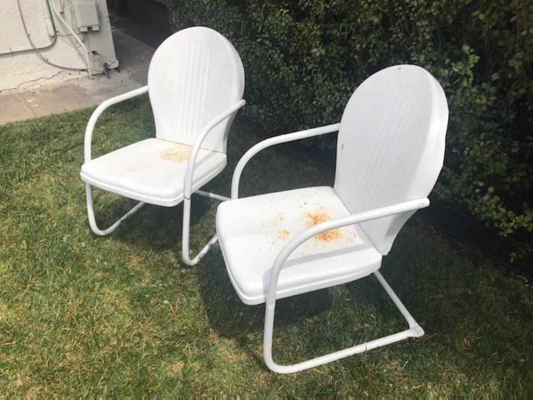 This funky pair of lawn or beach chairs are in old white painted surface. The undercoat is in robin egg blue. Sold as a pair.