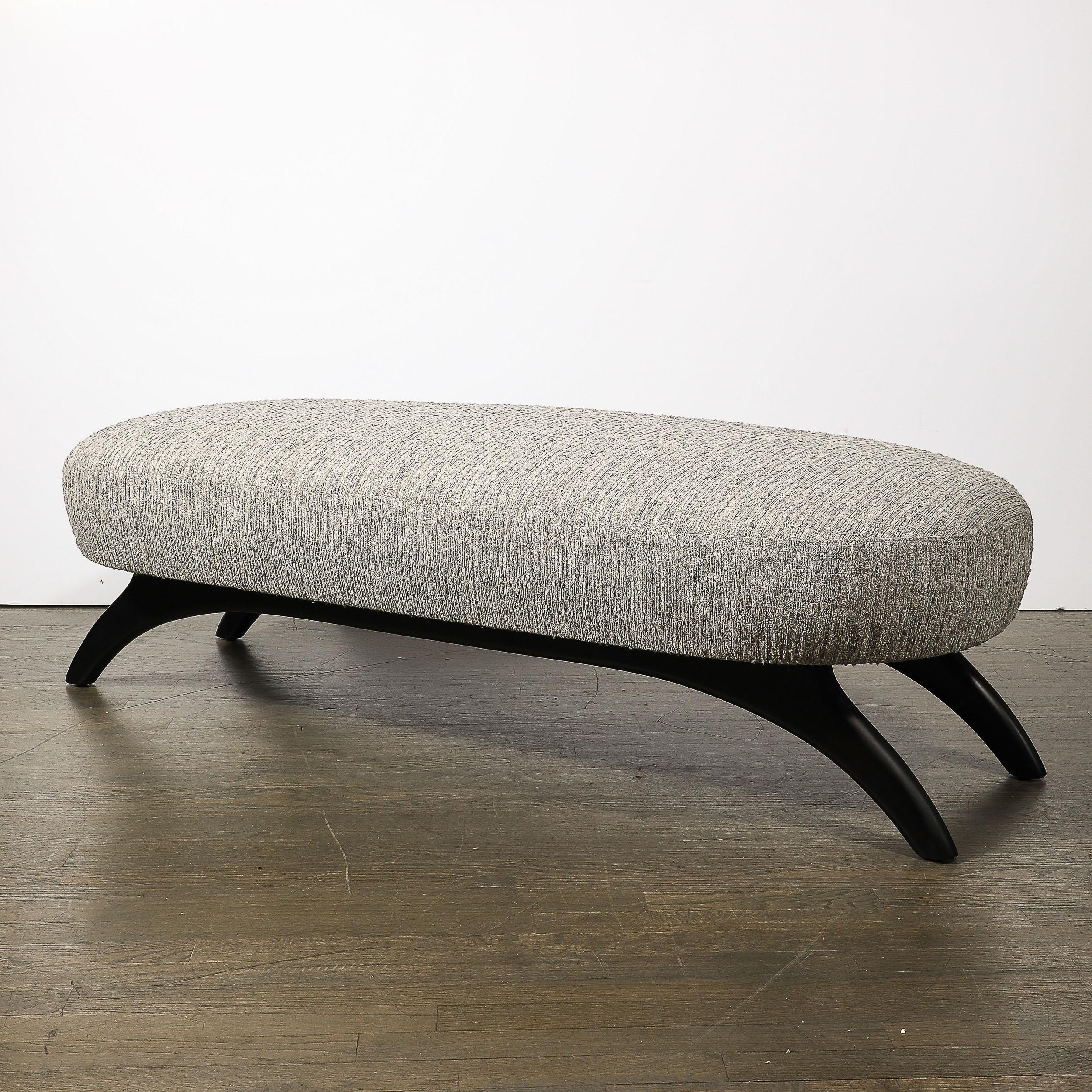 This well scaled Mid-Century Modernist Oval Bench W/ Sculptural Ebonized Walnut Supports by Adrian Pearsall originates from the United States, Circa 1950. This piece features a upholstered seat upholstered in a neutral grey striated Holly Hunt