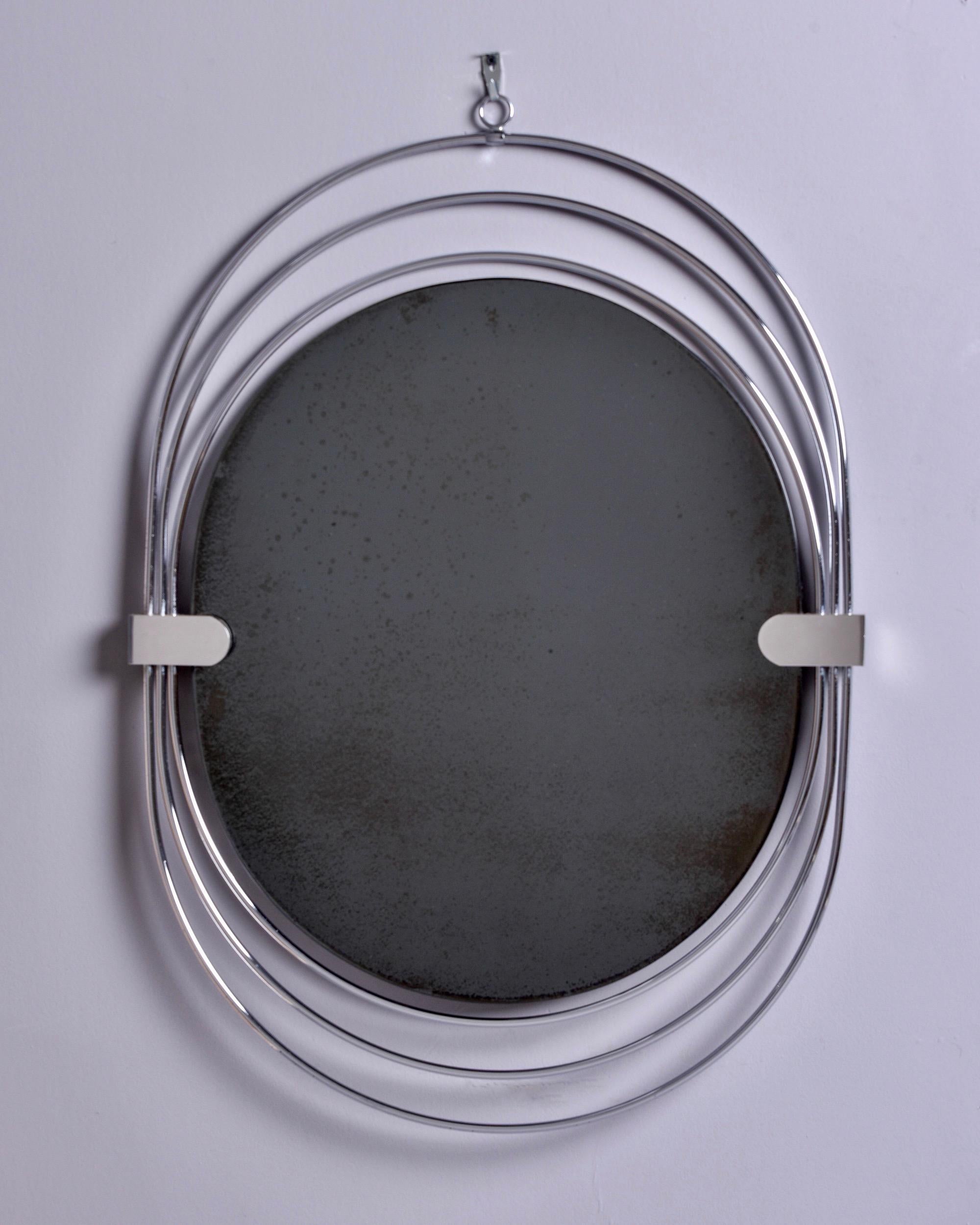 Found in France, this circa 1970s oval mirror has an unusual frame of three elongated chrome ovals gathered with bands at the sides and hanging ring at the top. Unknown maker. Very good vintage condition. 

Actual mrror size: 22” H x 19.25” D.