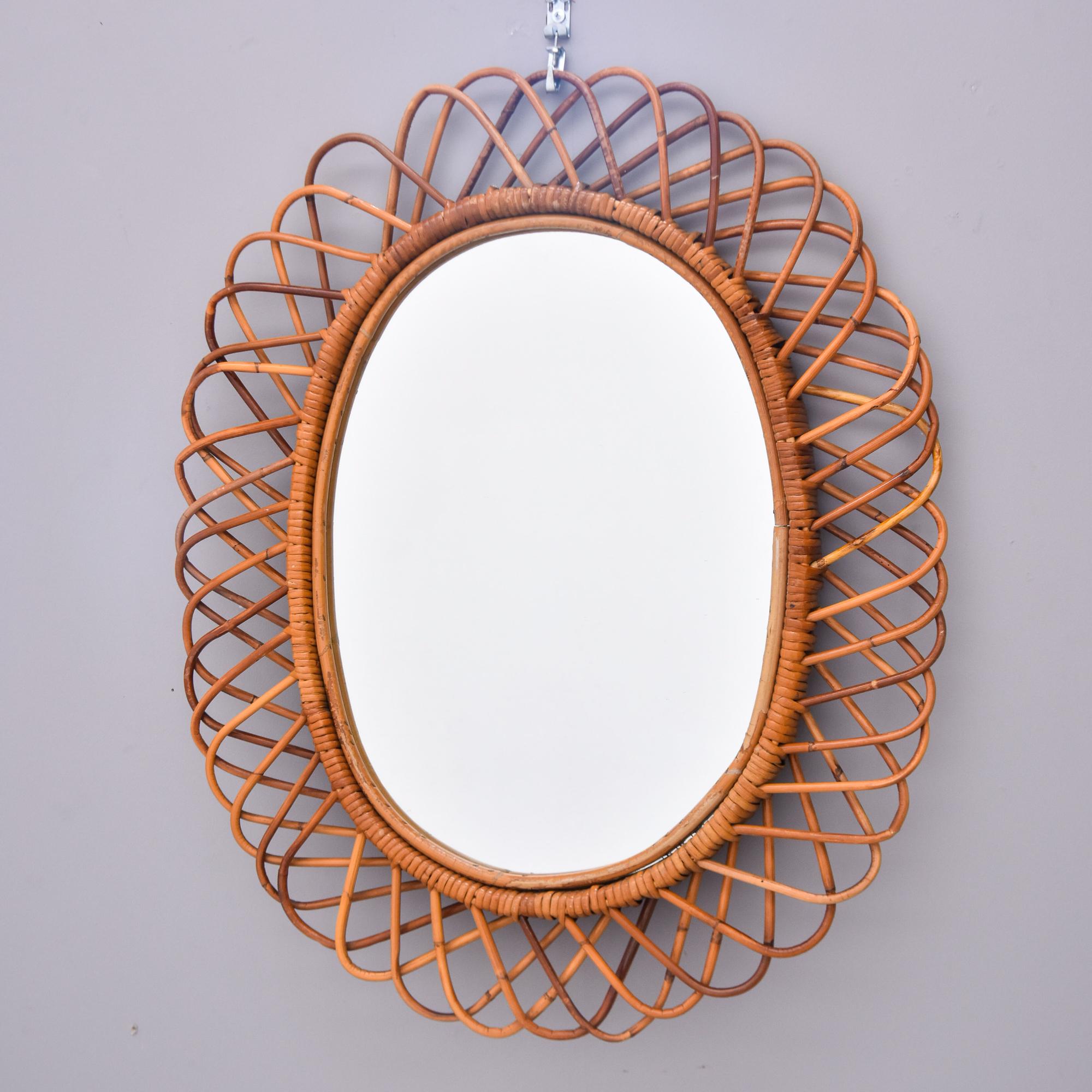 Found in Italy, this wicker framed mirror dates from approximately 1970. Oval mirror itself is 20” high by 14.5” wide and has a wide, open weave wicker or narrow reed rattan frame. Unknown maker. 

Very good vintage condition with no breaks or