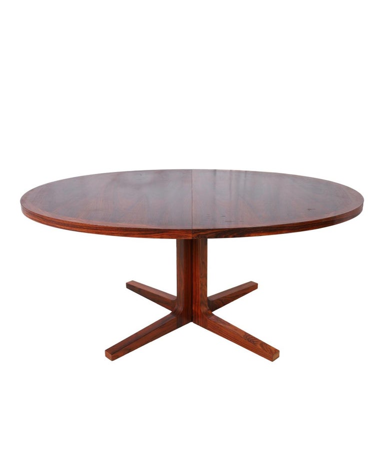 Stunning mid century rosewood oval Danish Modern extension dining table with (2) leaves. This table has Solid rosewood wood legs. This table is in beautiful condition with Dark black and reddish rosewood tones very great Table. high quality