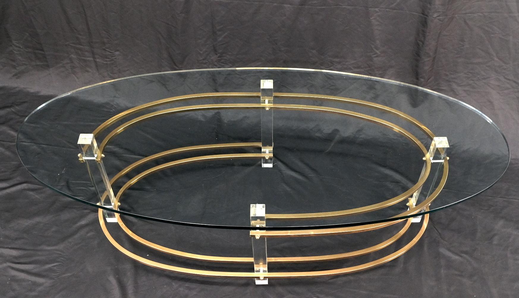 Mid-century oval thick glass top lucite brass base coffee table. Atr. Charles Hollis Jones.