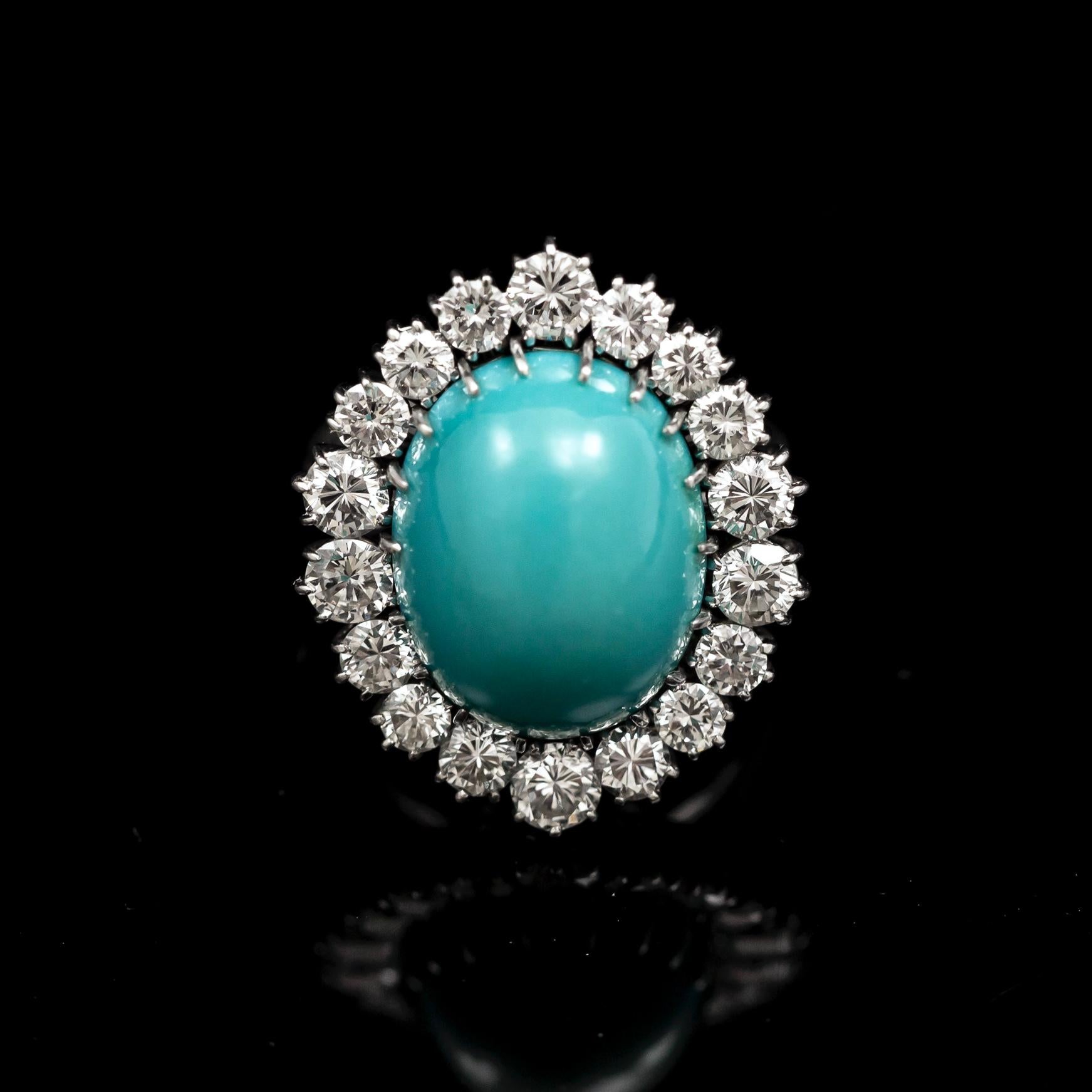 A Mid-Century turquoise and diamond cluster cocktail ring in platinum, 1950s/1960s. Of a cluster design, this dress ring features an oval cabochon turquoise stone claw-set to the center, surrounded by 18 round brilliant-cut diamonds of similar sizes