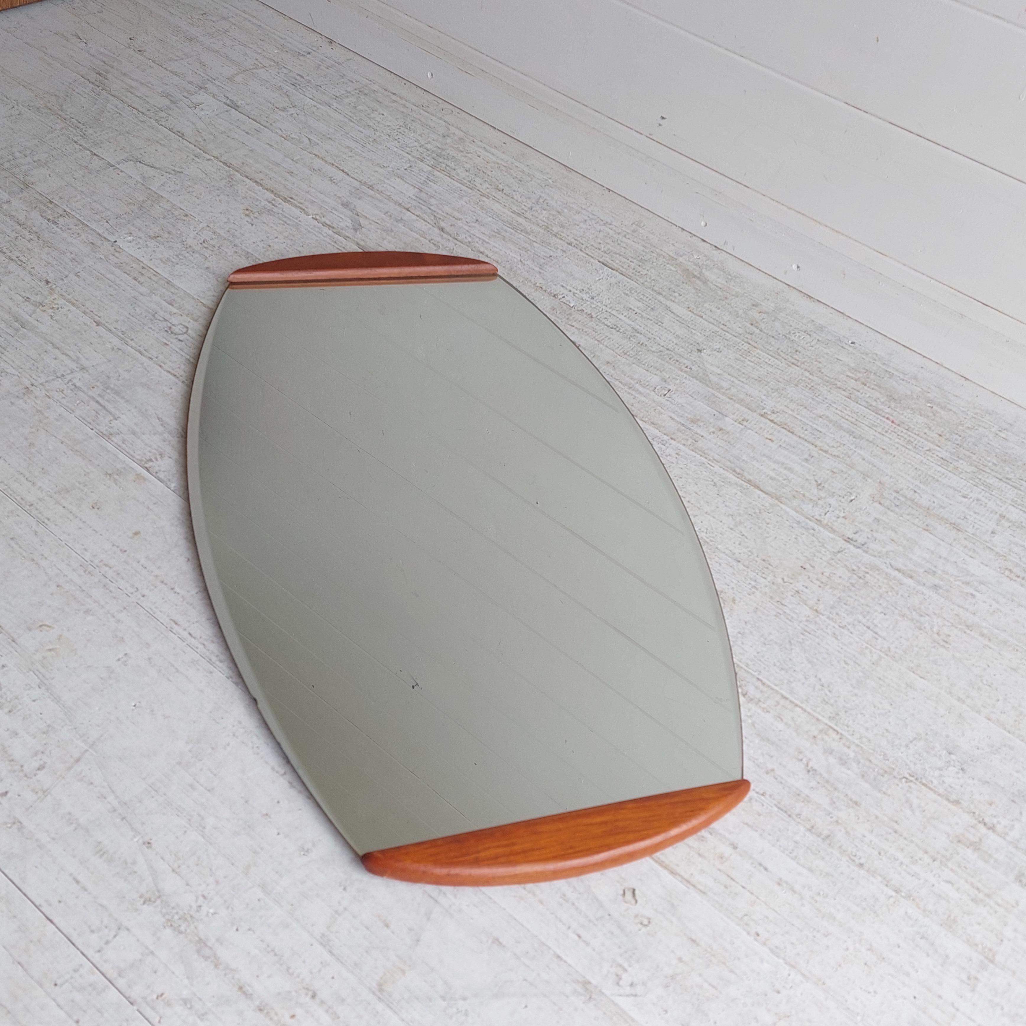 Teak framed Wall Mirror Designed and Manufactured most probably in Denmark in the 1960s

Stunning Elliptic Wall Mirror that would work in any room in your home, 
Magnificent oval beveled mirror with 2 teak parts at the top and bottom
A model dating