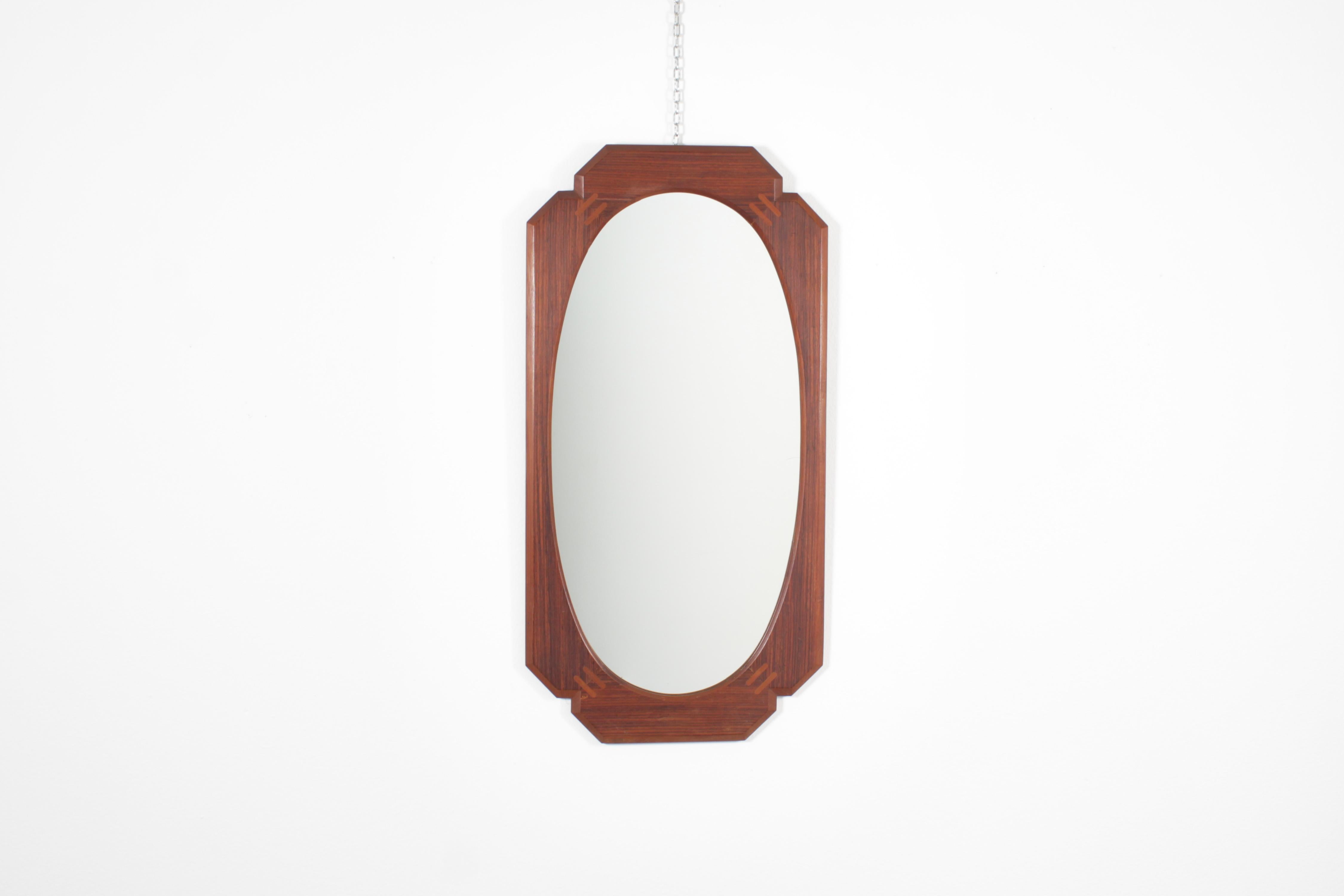 Specchio da parete con grande cornice geometrica in legno smussato con specchio ovale all'interno.
Produzione italiana degli anni '60.
Usura coerente con l'età e l'uso.