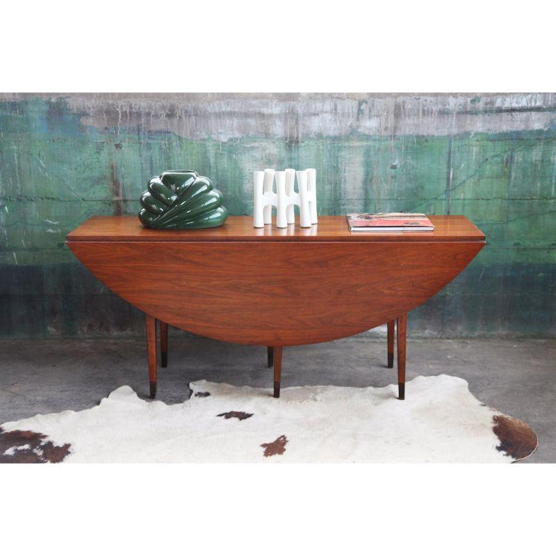Stunning Oval shaped vintage American Edward Wormley dining table that can also be used with its leaves down as a console table behind the couch or a buffet table.
 
Featured beautiful book matched walnut wood grain,. Very rare and sought after
