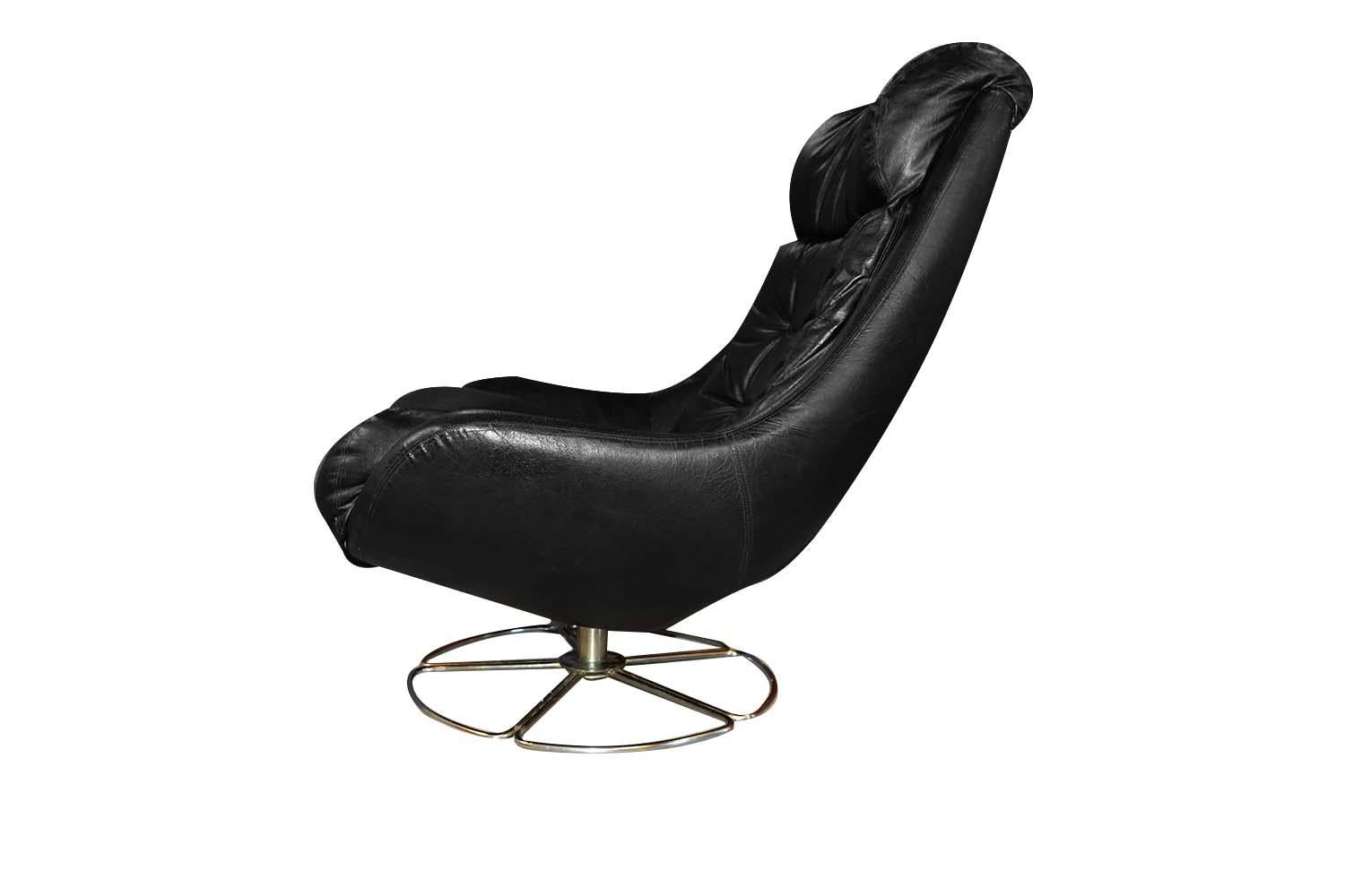 Fantastic midcentury, overman style, pod, high back, swivel, lounge chair, circa 1970s. Featuring a generously padded, high back and headrest to ensure maximum comfort and support. Upholstered in handsome, tufted, rich black, original, faux leather.