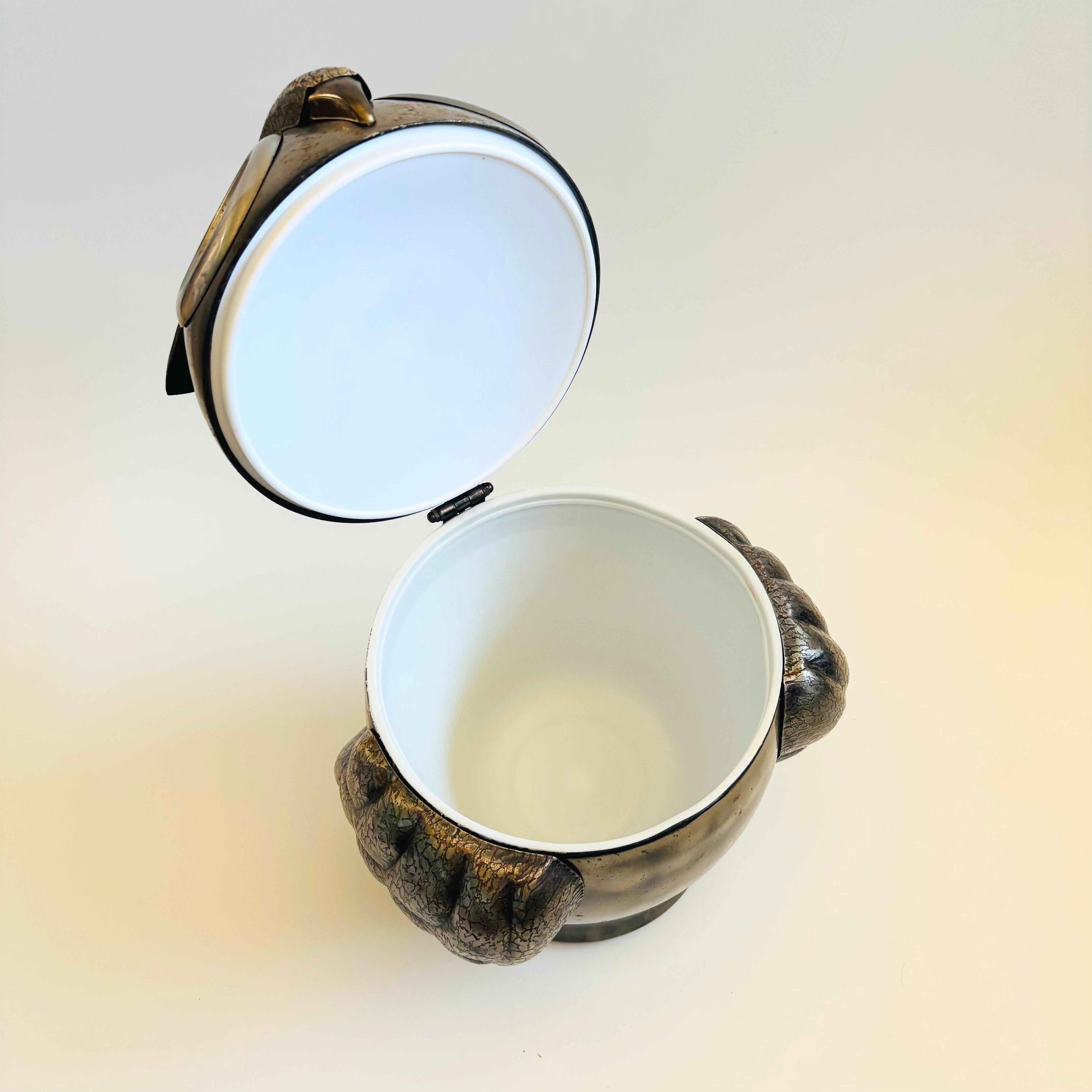 A wonderful vintage ice bucket in the shape of an owl. Made in Japan by Seymour Mann. Great deco detailing throughout and a nice large size. Made of metal with a white plastic interior liner.

