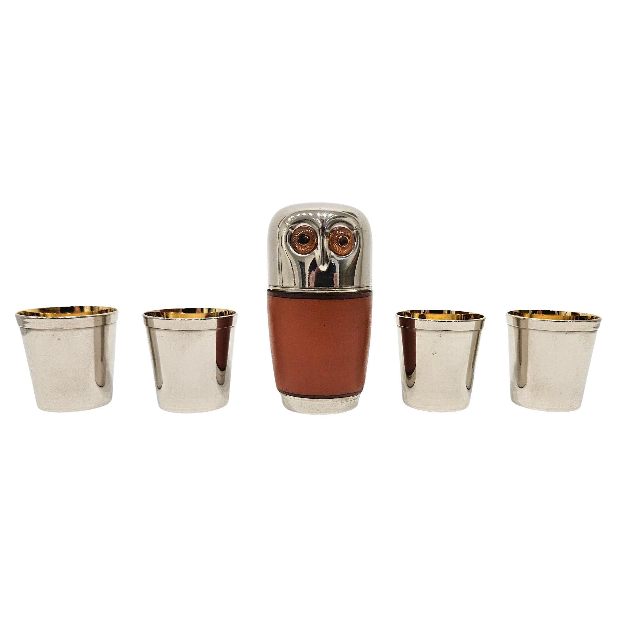 A charming mid century complete set of four animal-theme shot cups nested within an owl-shaped case, made in Germany c. 1960.

The owl has orange eyes and a stylishly designed chrome-finish head. The beak is described with very clean industrial