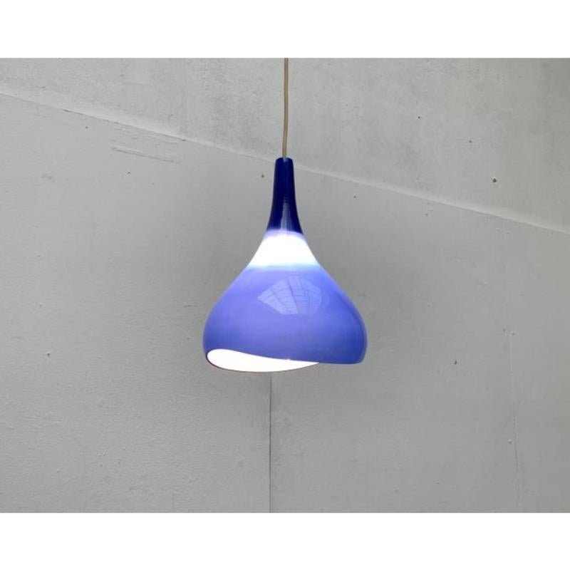 Lampada a sospensione in vetro Krokus del produttore danese Nordisk Solar su progetto di Sigvard Bernadotte e Acton Bjørn degli anni '60.

Il corpo dell'apparecchio, a forma di goccia, è realizzato interamente in vetro opalino e arancione. La
