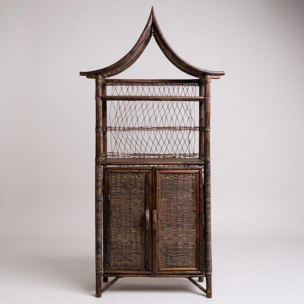 Se trata de un mueble de ratán en forma de pagoda. Tiene dos puertas que se abren a estanterías. El cuerpo mide 26,5